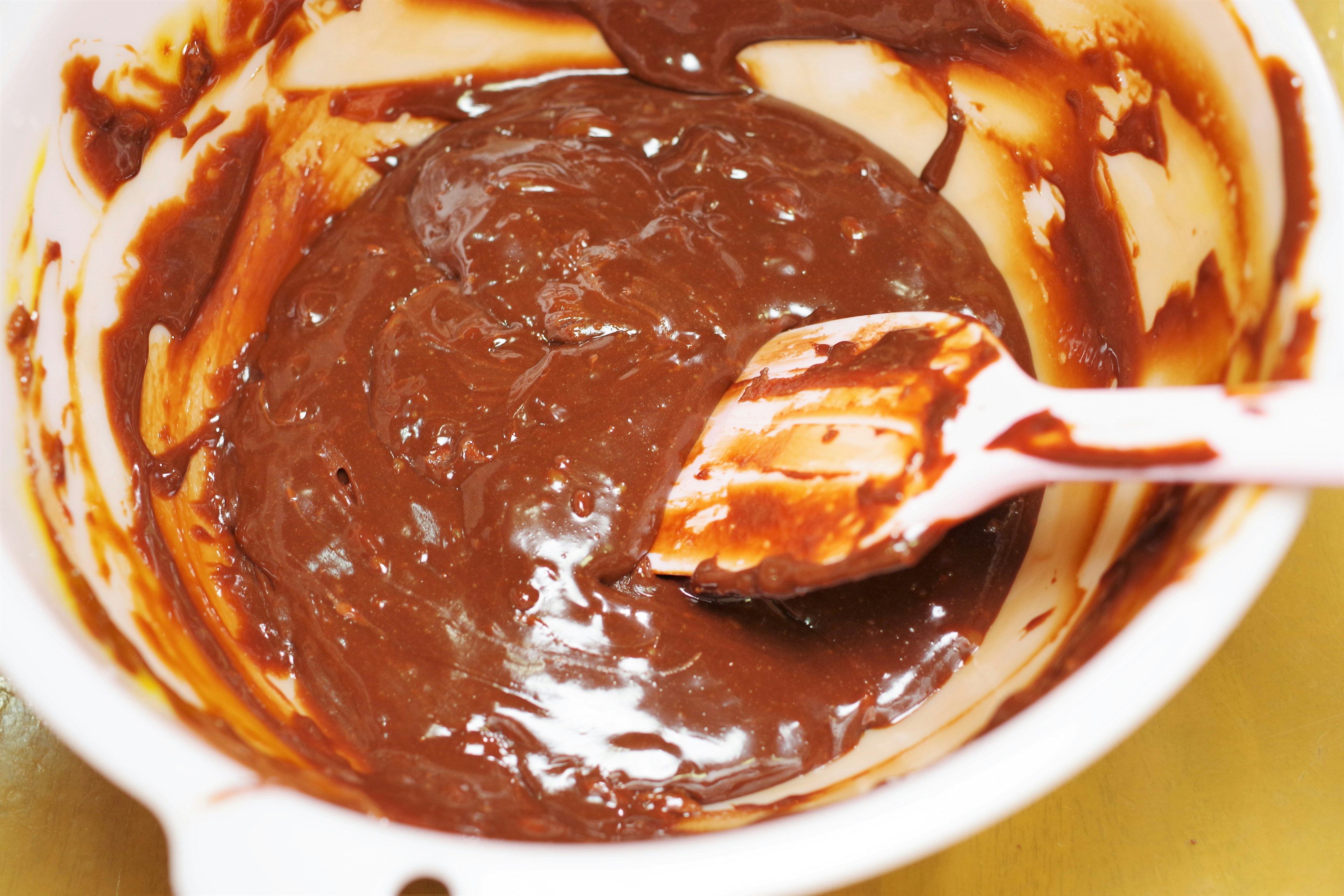 Masa de chocolate en un tazón blanco con una espátula