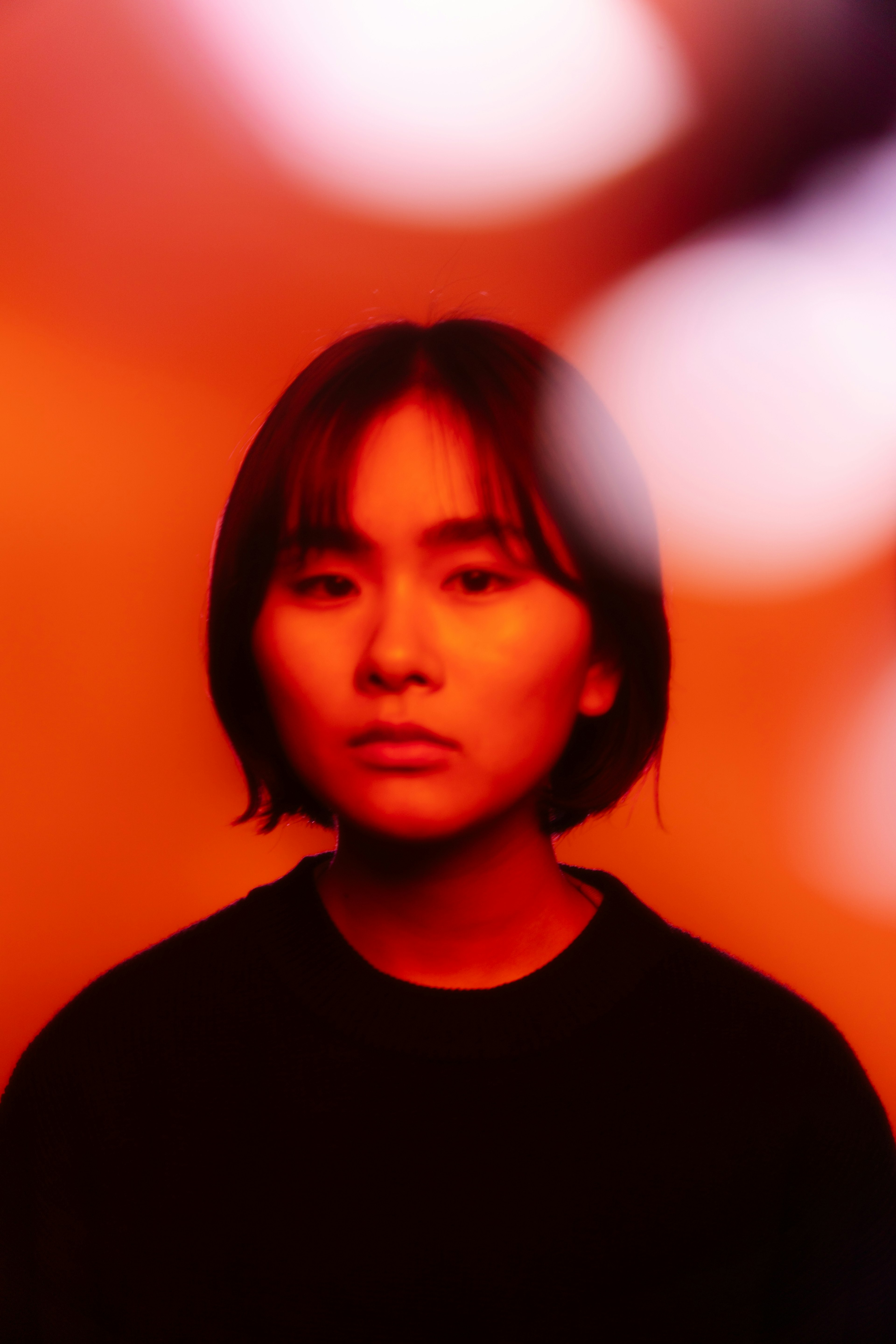 Portrait of a woman with a serious expression against a red background