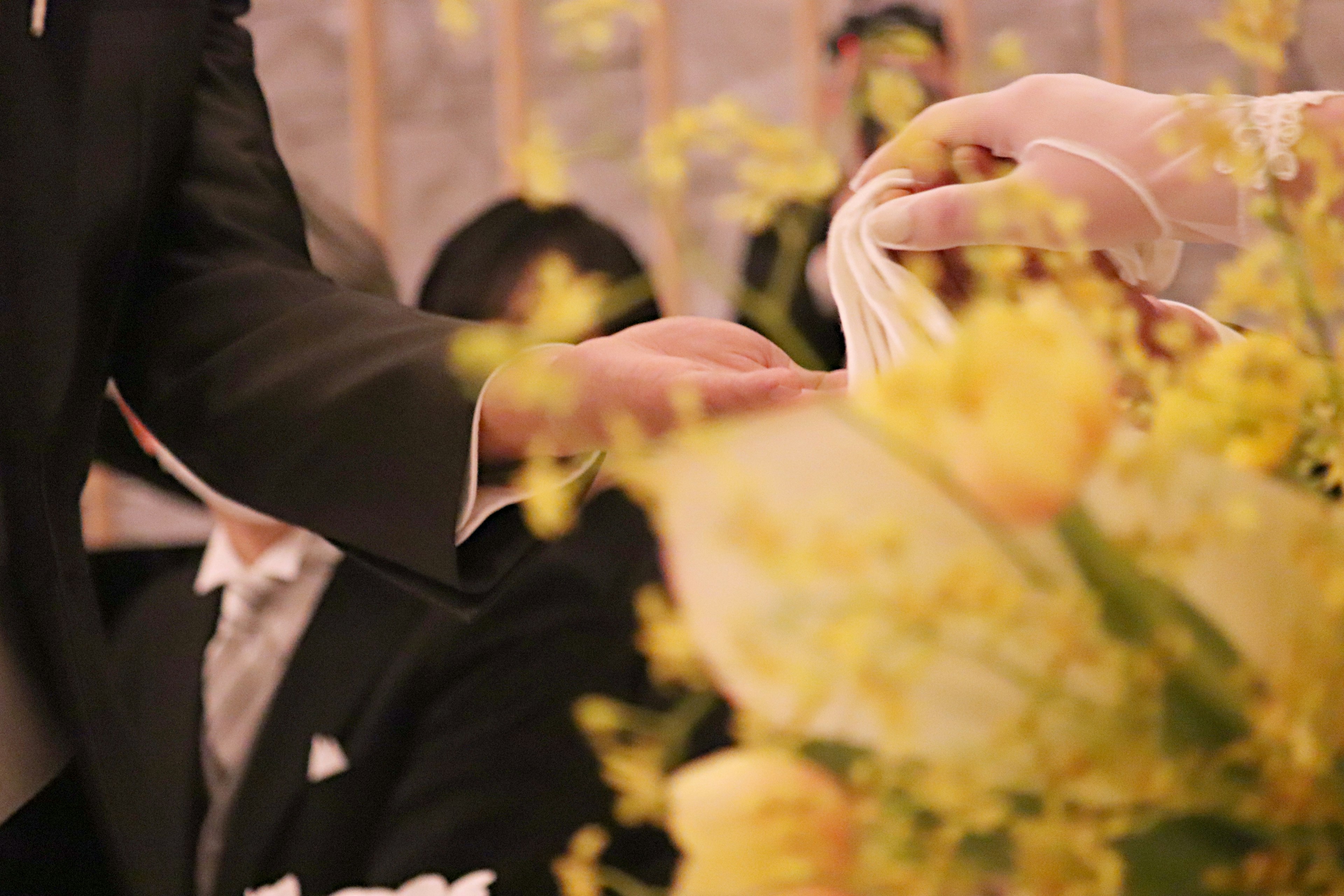 Moment de remise lors d'un mariage avec un bouquet de fleurs jaunes