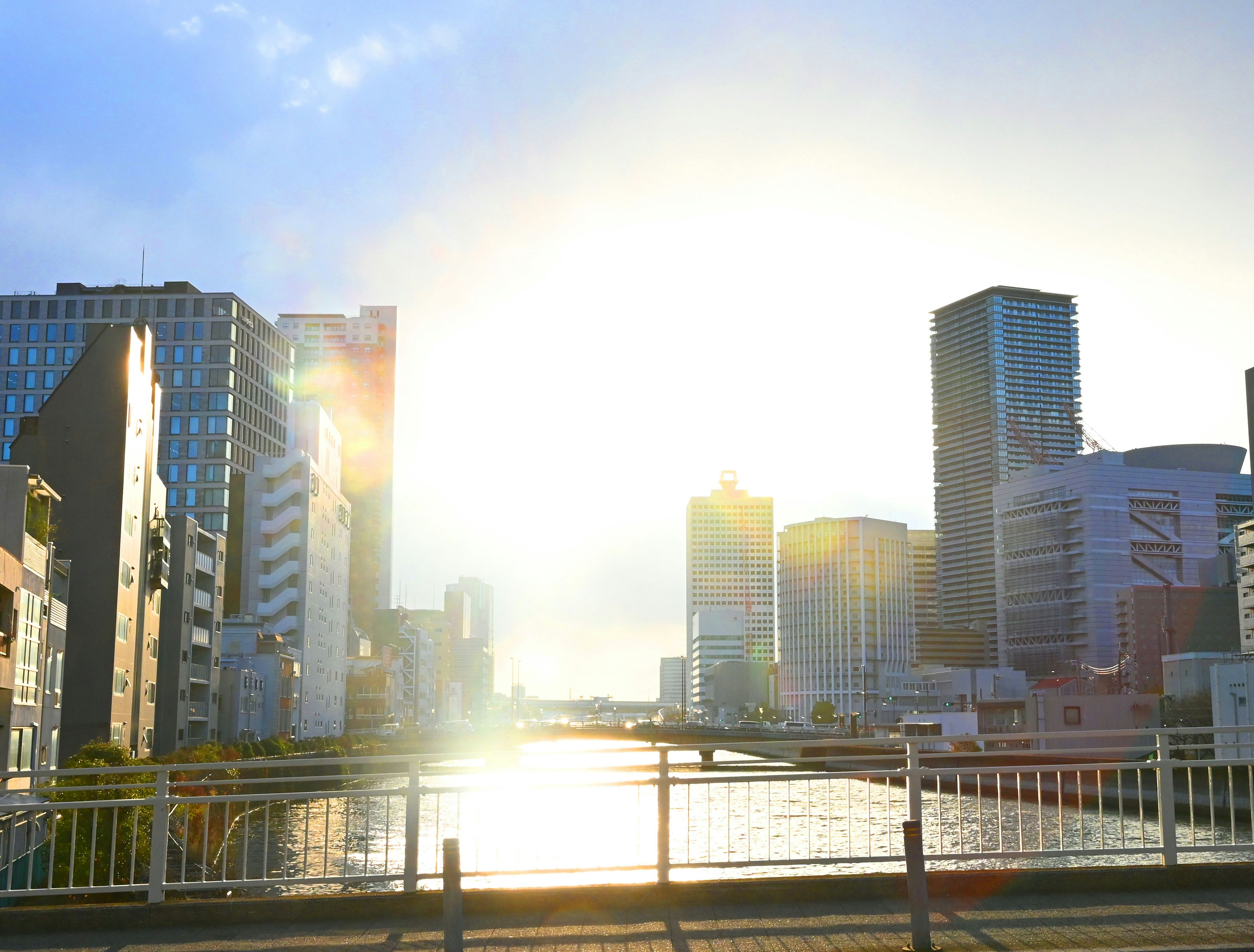 Cityscape with modern buildings reflecting sunset on the river