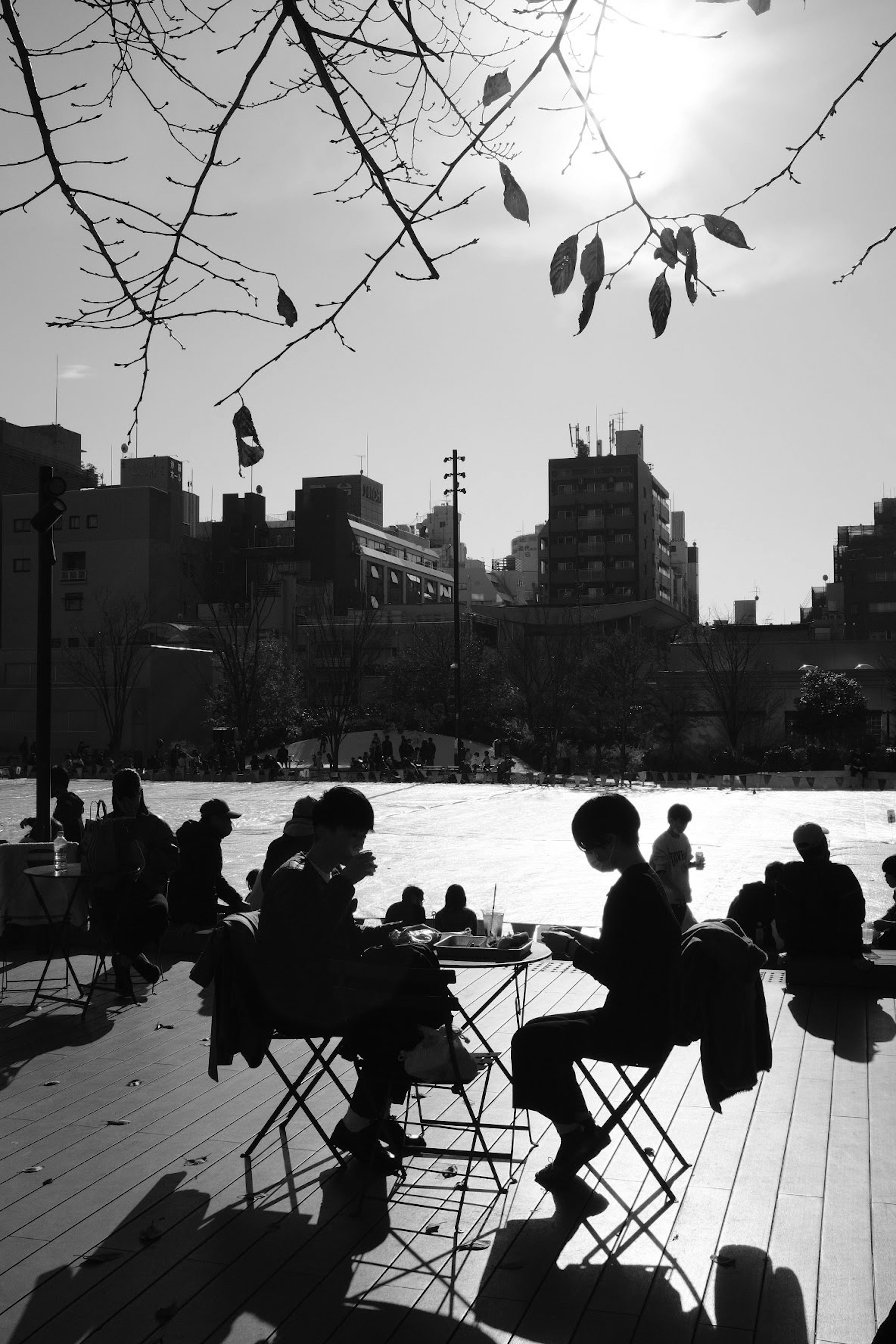 Silhouettes of people sitting by the water in black and white