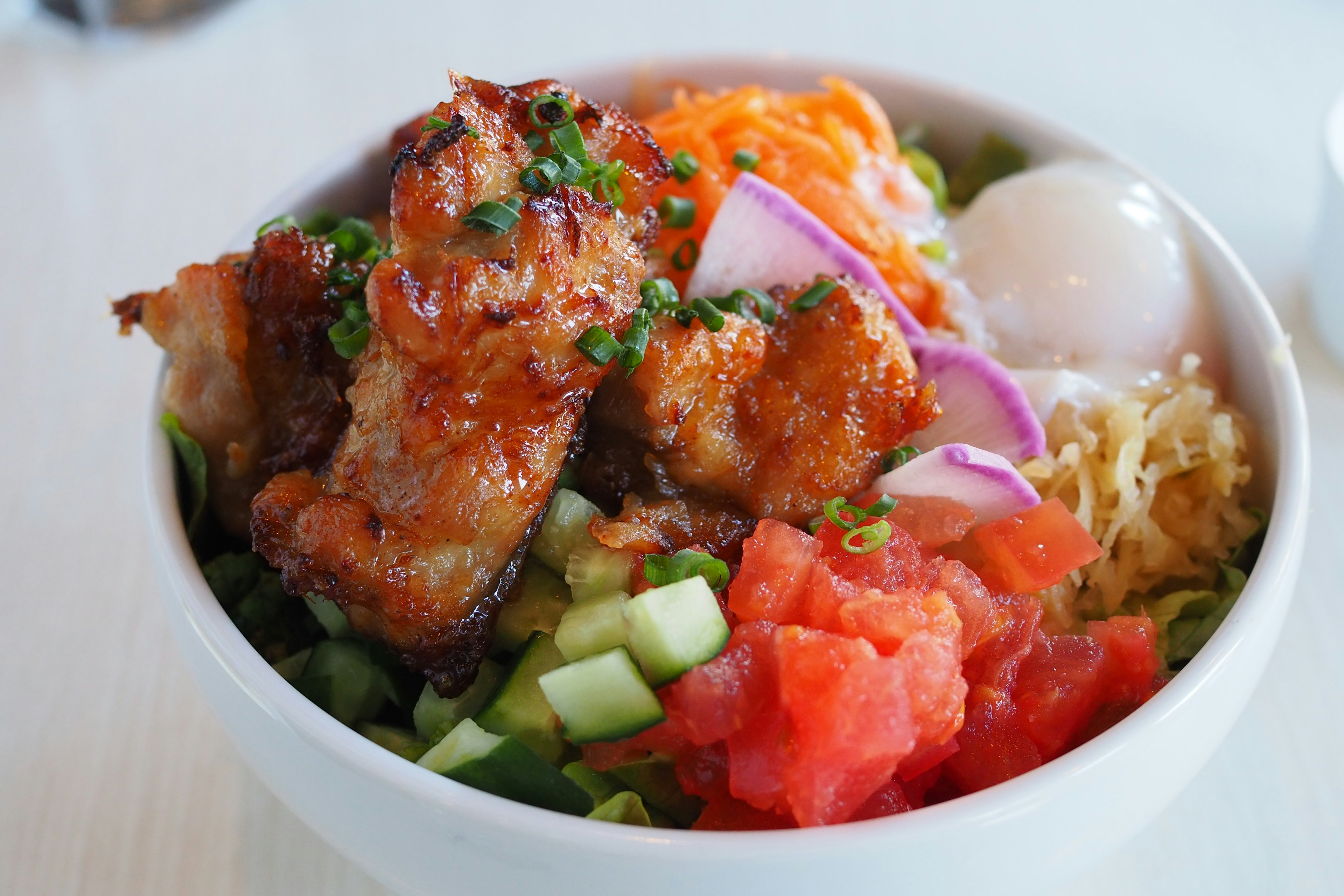 Delicious chicken bowl topped with fresh vegetables