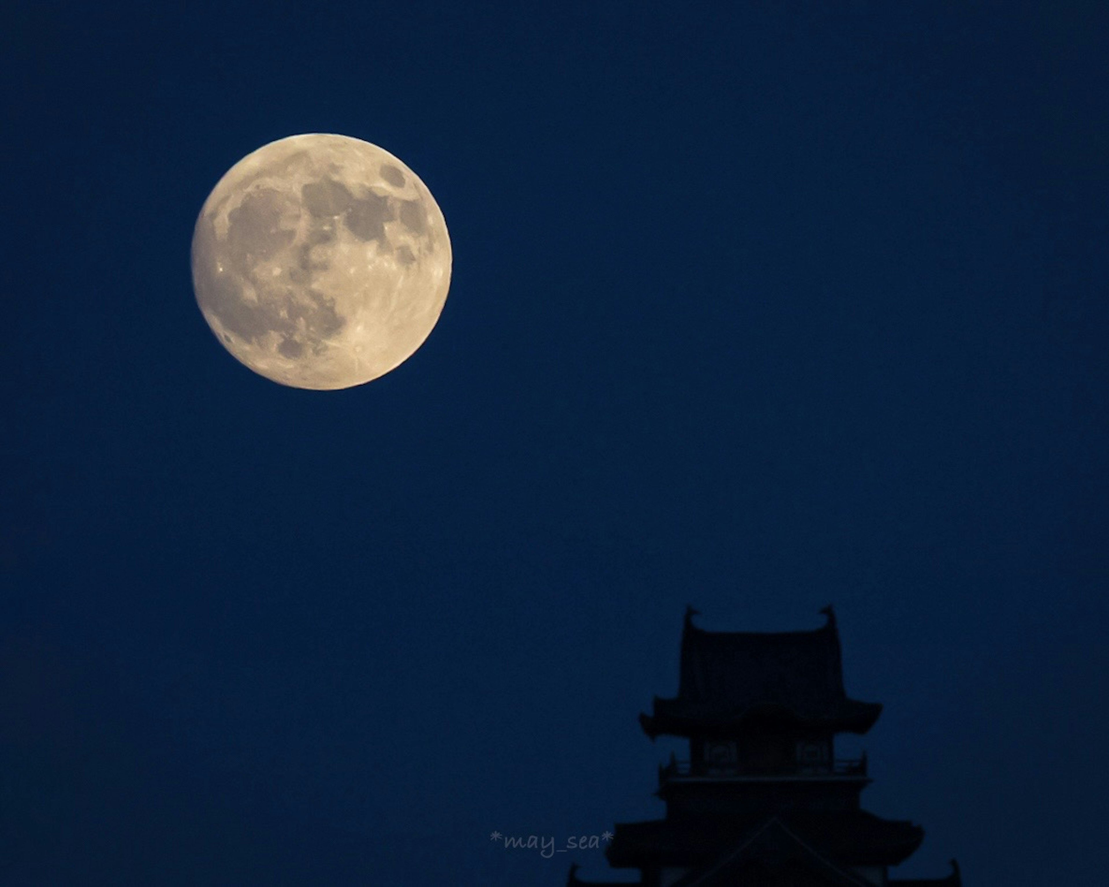 Große Vollmond im Nachthimmel mit silhouettierter Turm