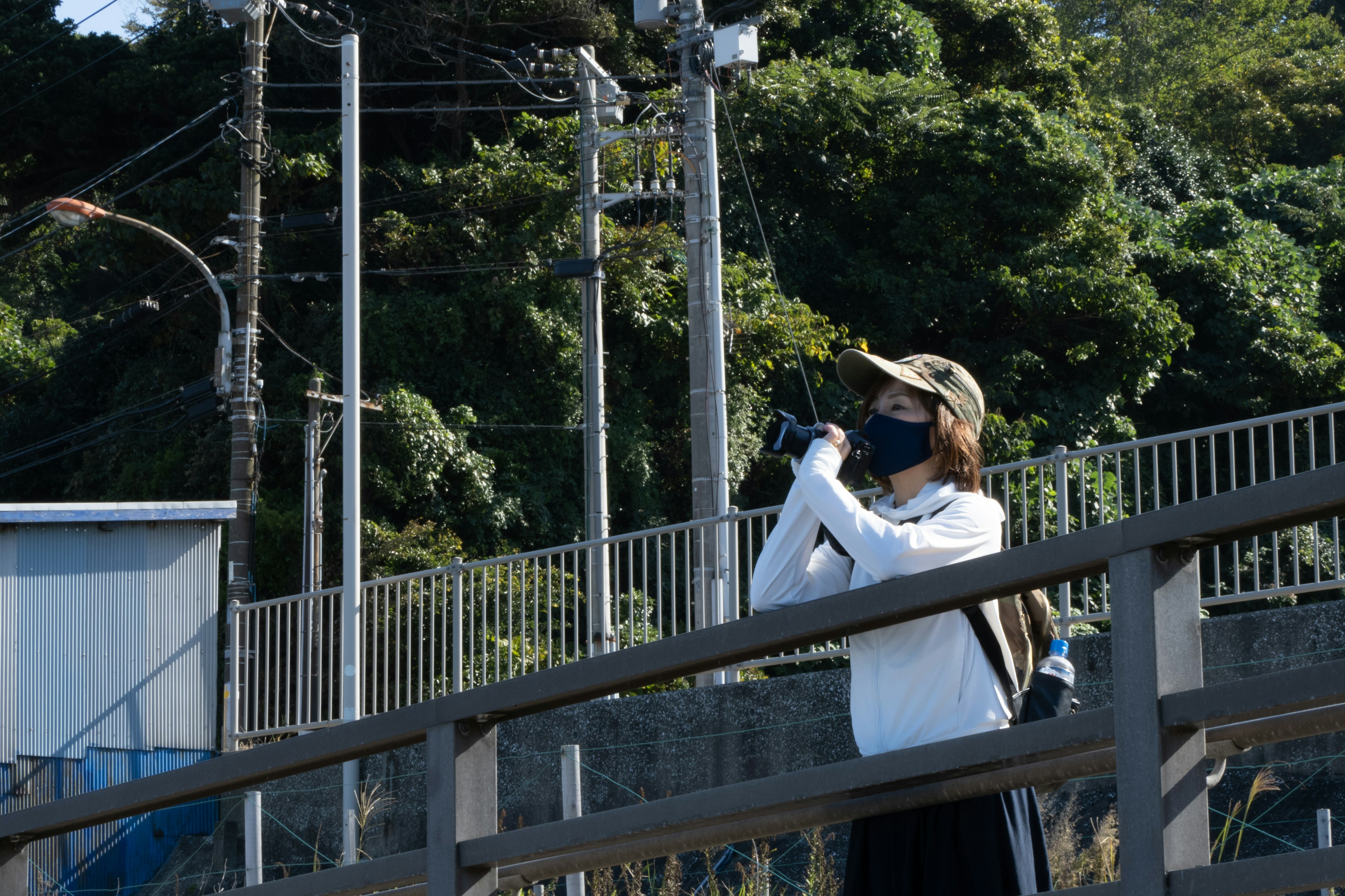 カメラを持って撮影する女性と緑の背景