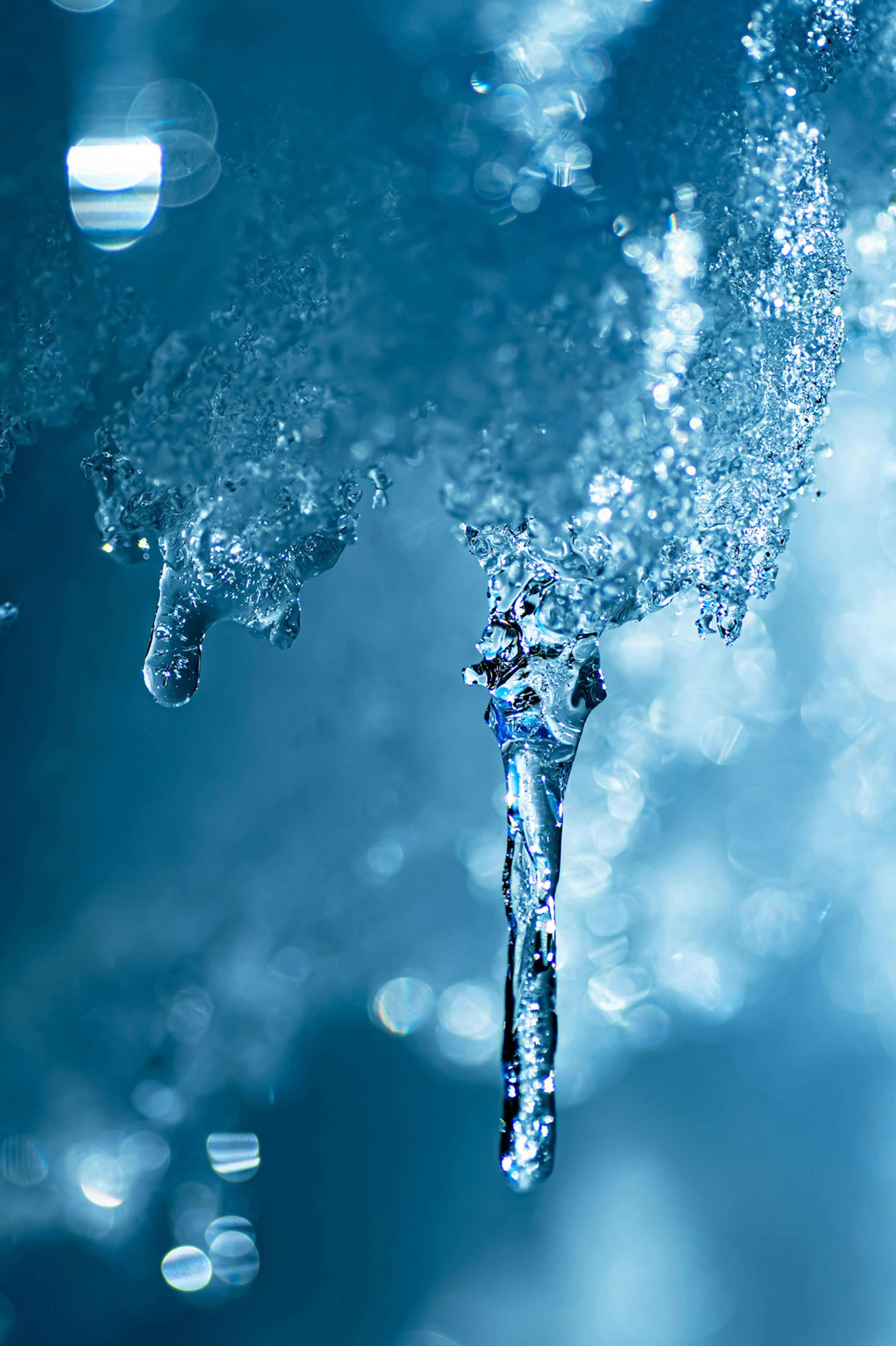 氷の滴と青い水の背景のクローズアップ