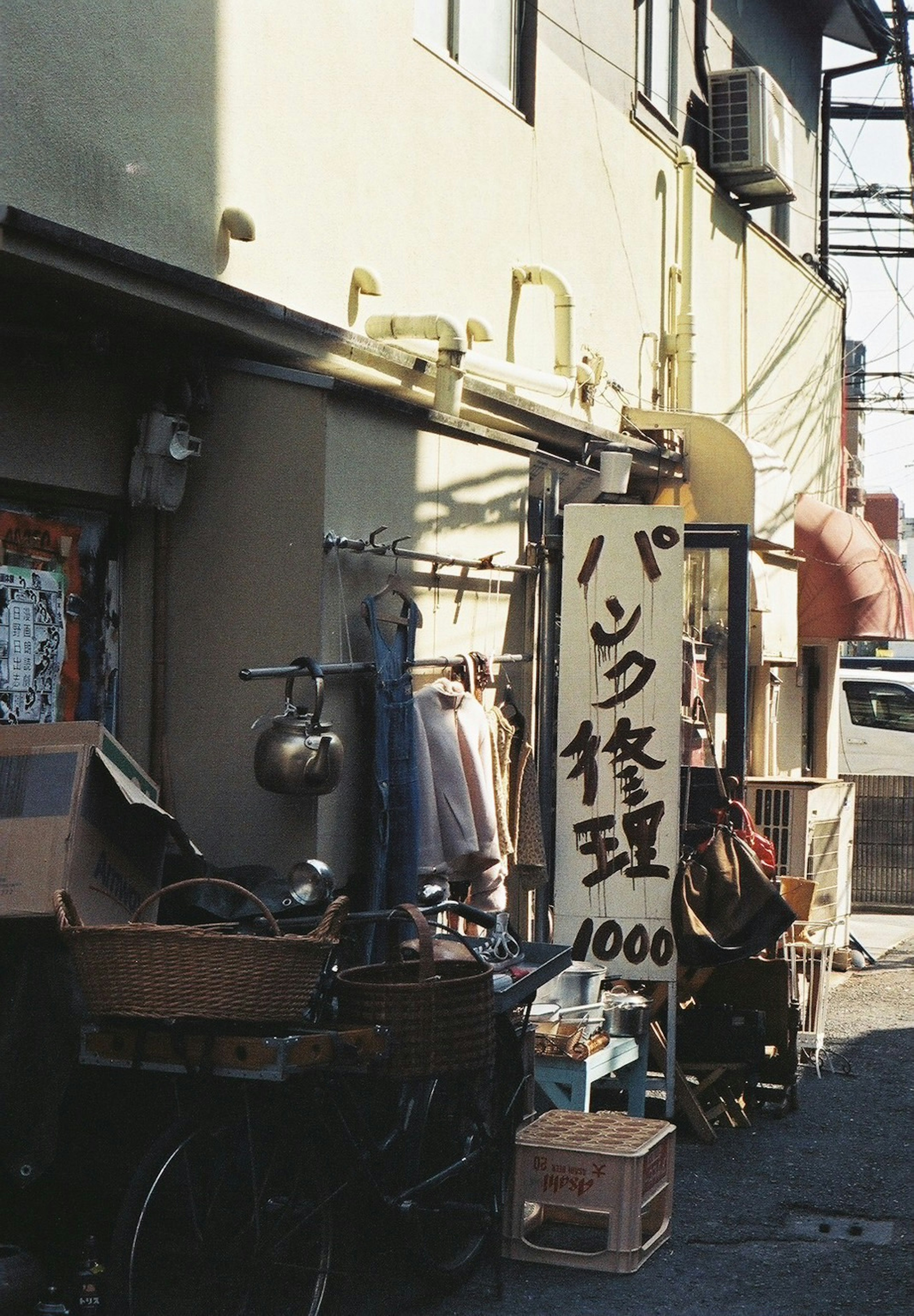 狭い路地にある古い修理店の看板と散らかった道具