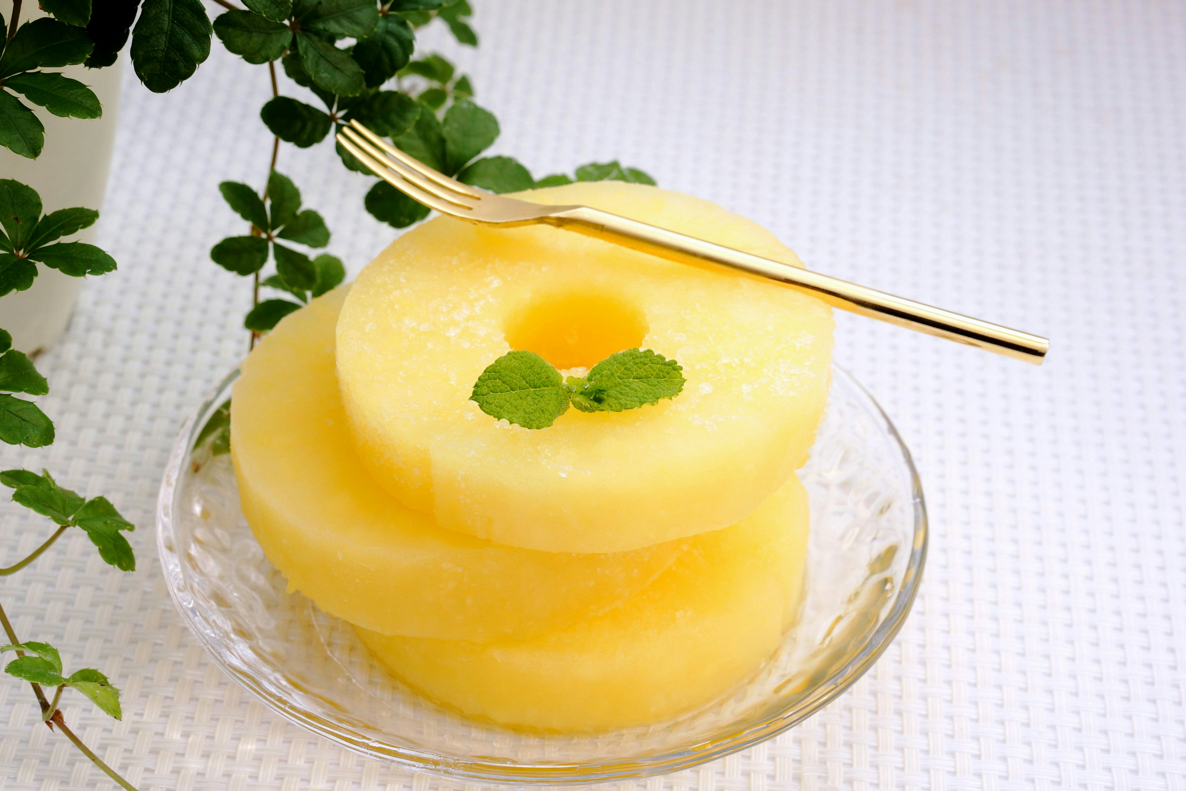 Rodajas de piña en un plato con hojas de menta