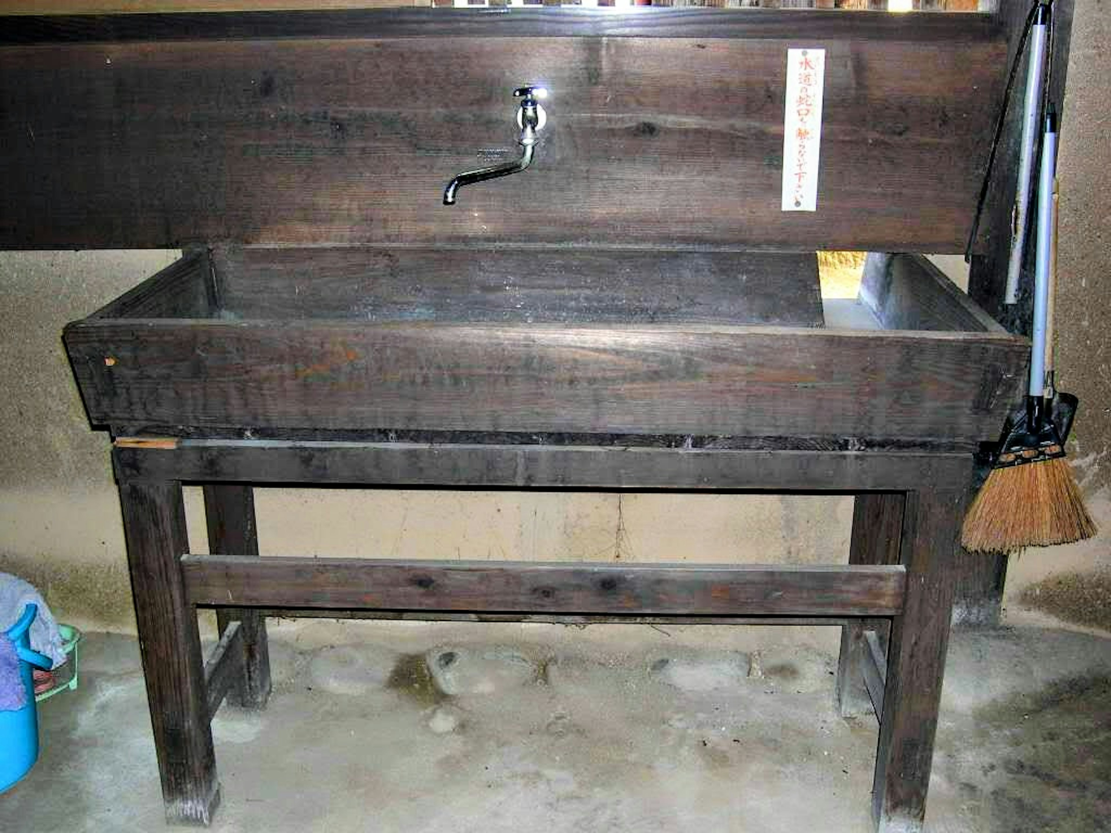 Simple wooden wash basin with a faucet and storage space