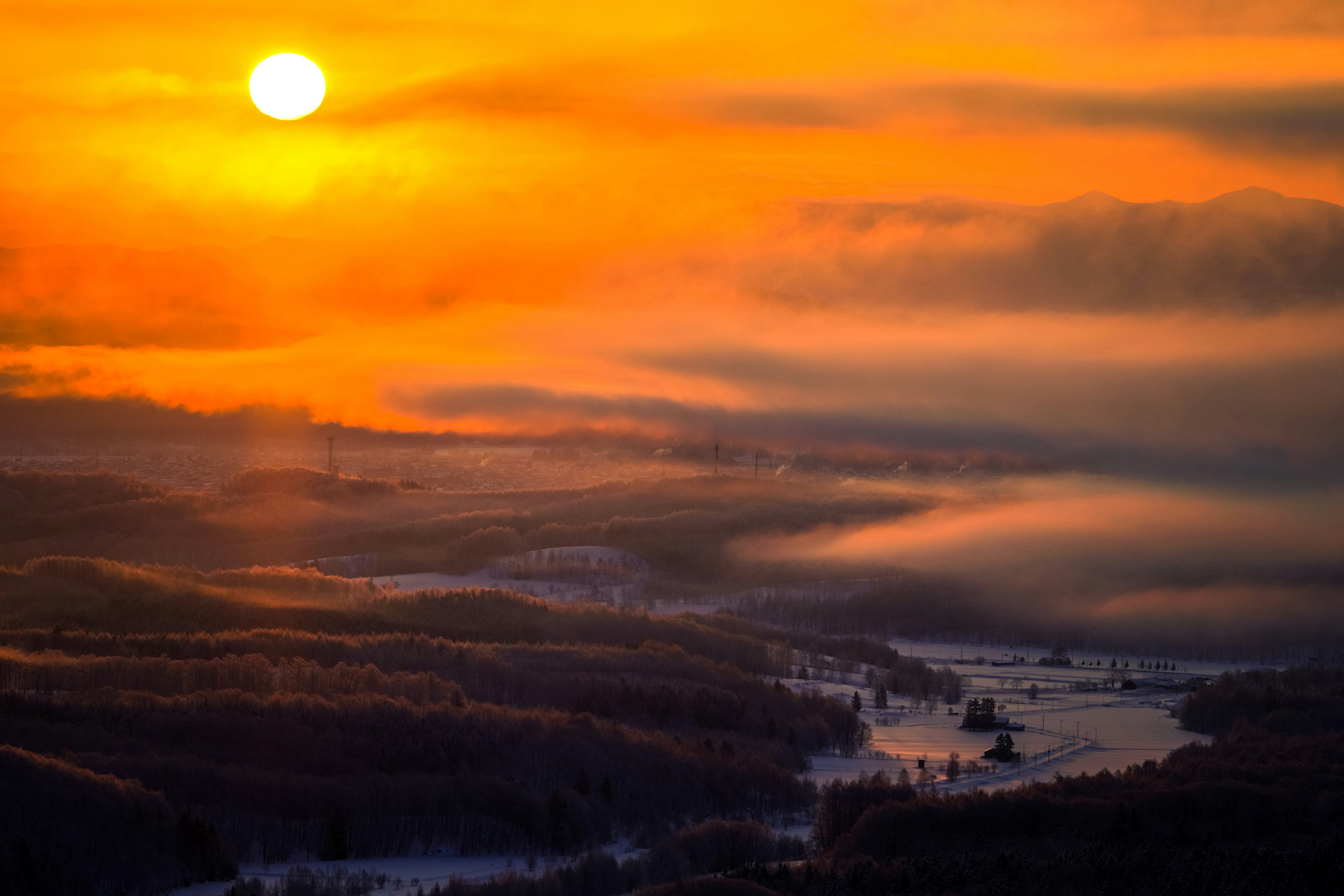 Malerscher Ausblick auf einen Sonnenuntergang über einer nebligen Flusslandschaft