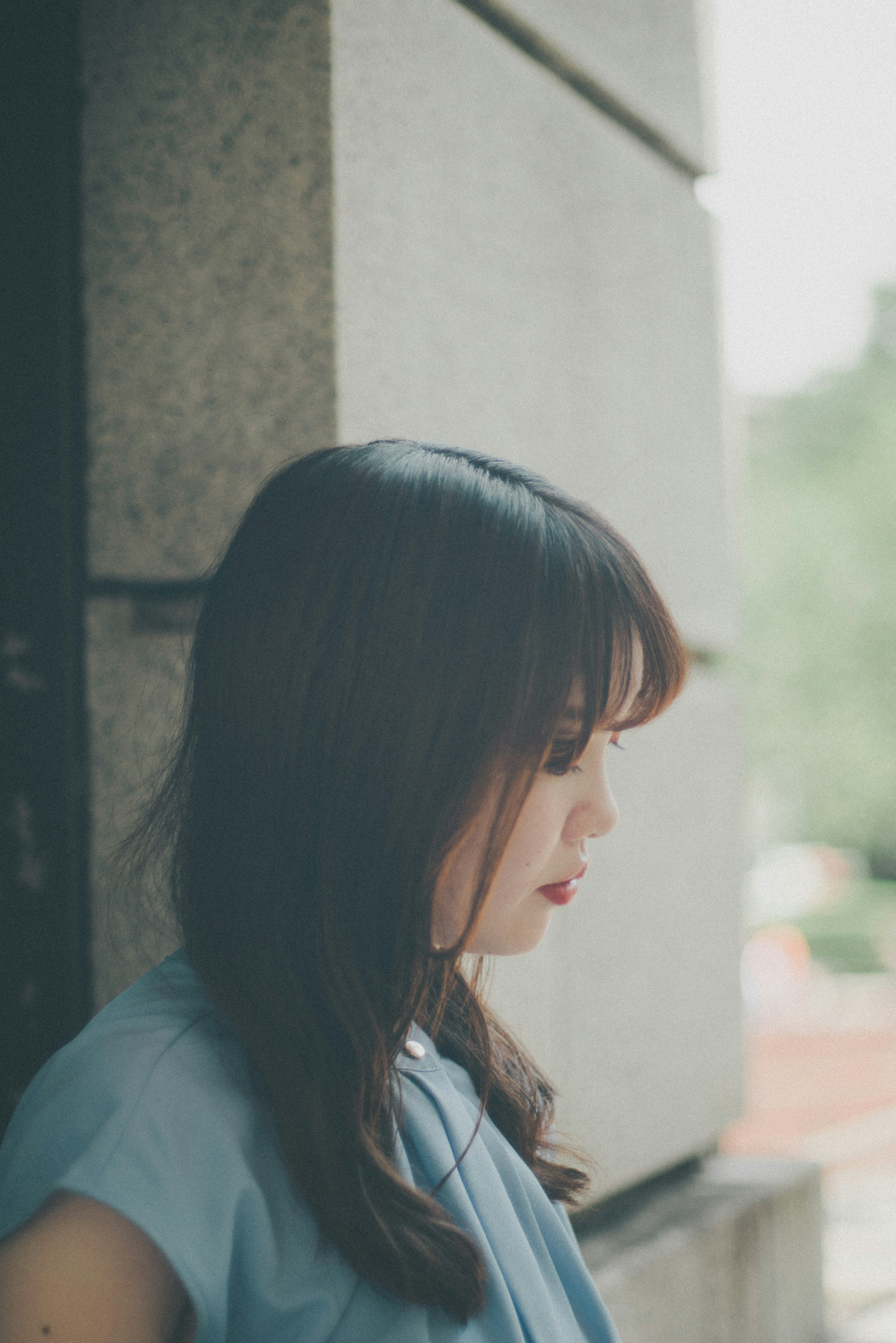 A woman lost in thought near a window