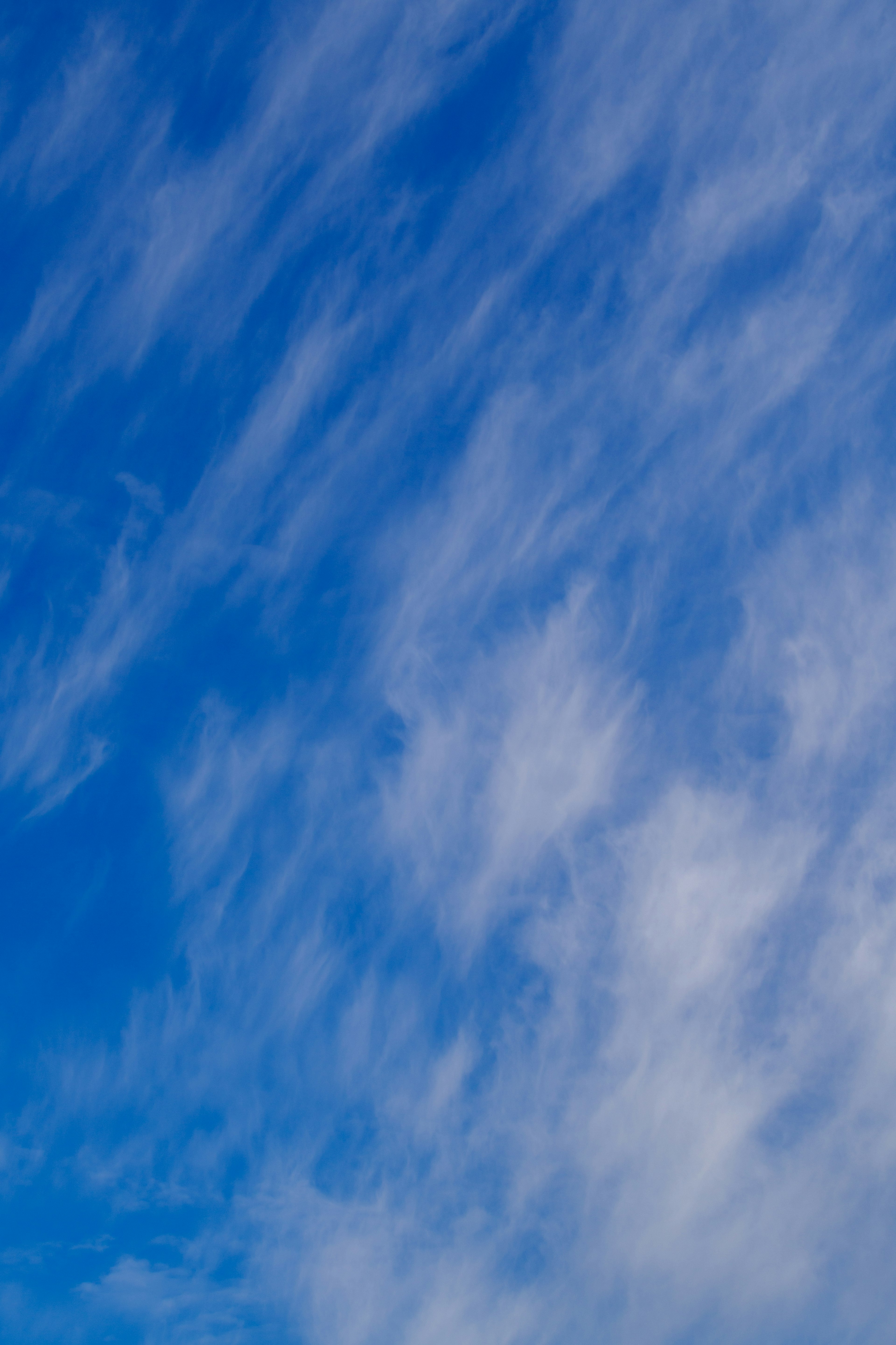 Muster aus dünnen Wolken vor blauem Himmel