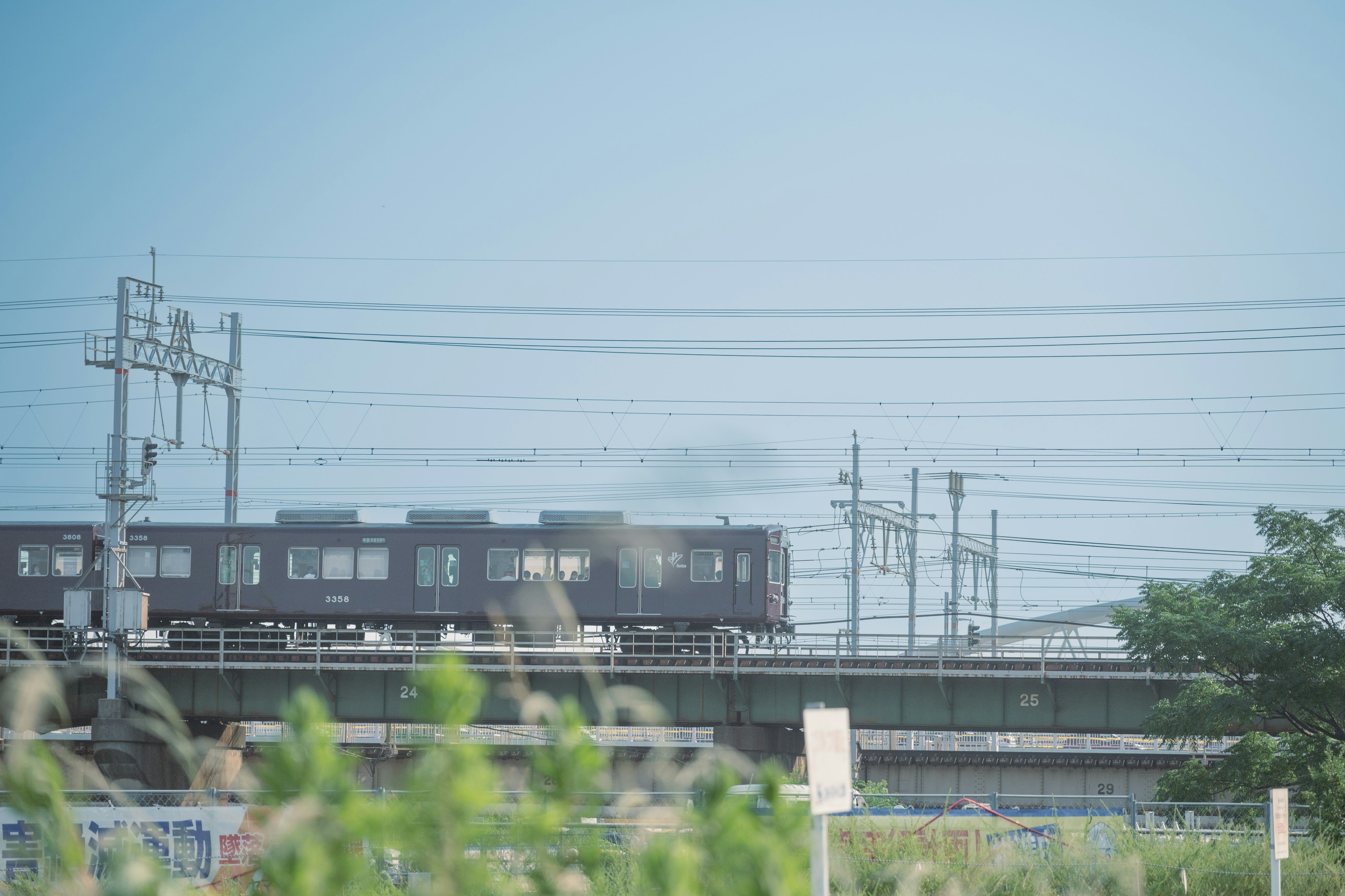 Black train running under blue sky with power lines