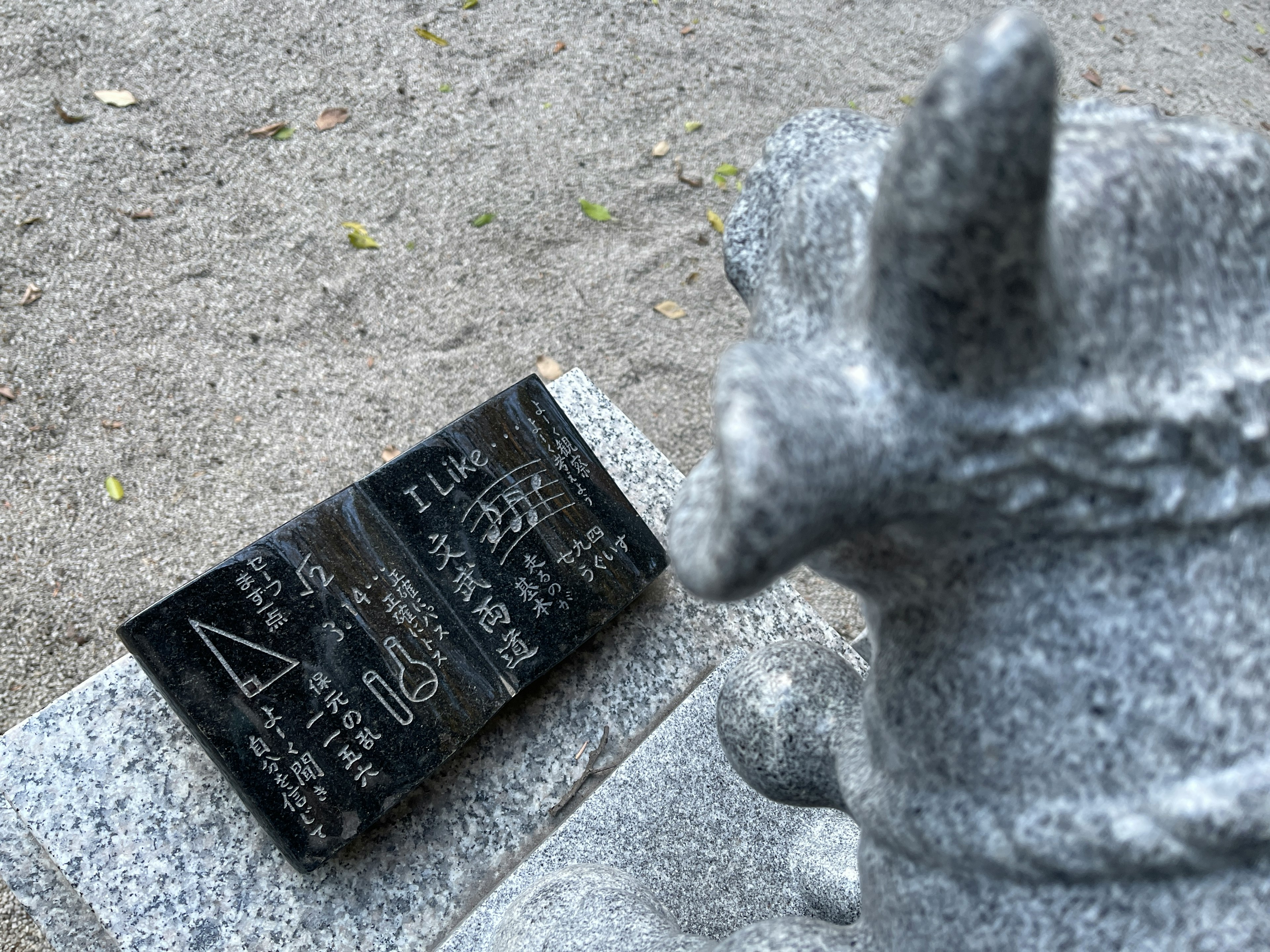 Escultura de piedra con una placa negra y inscripciones