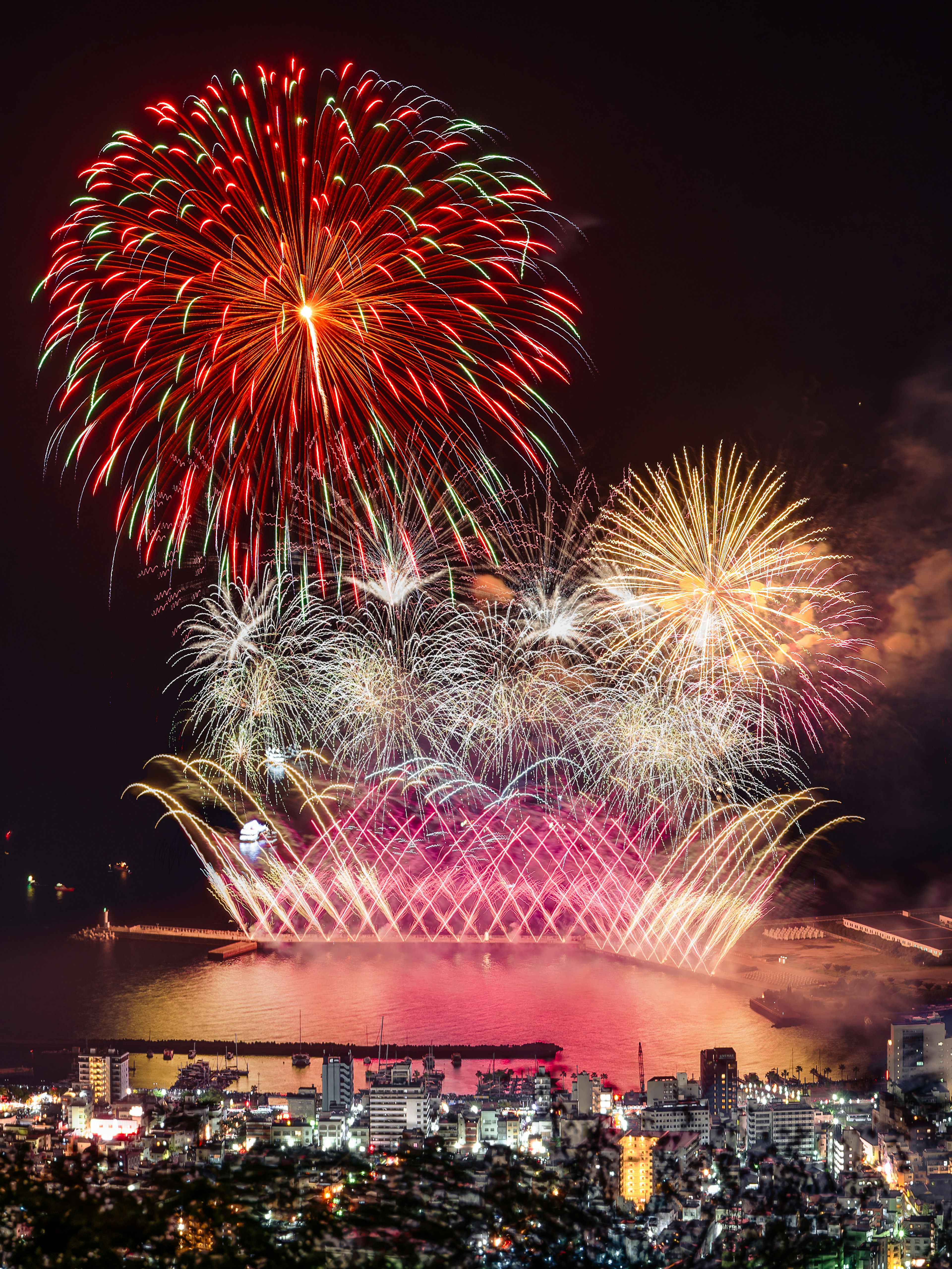 夜空を彩る花火が明るく上がり、都市の景色が広がる