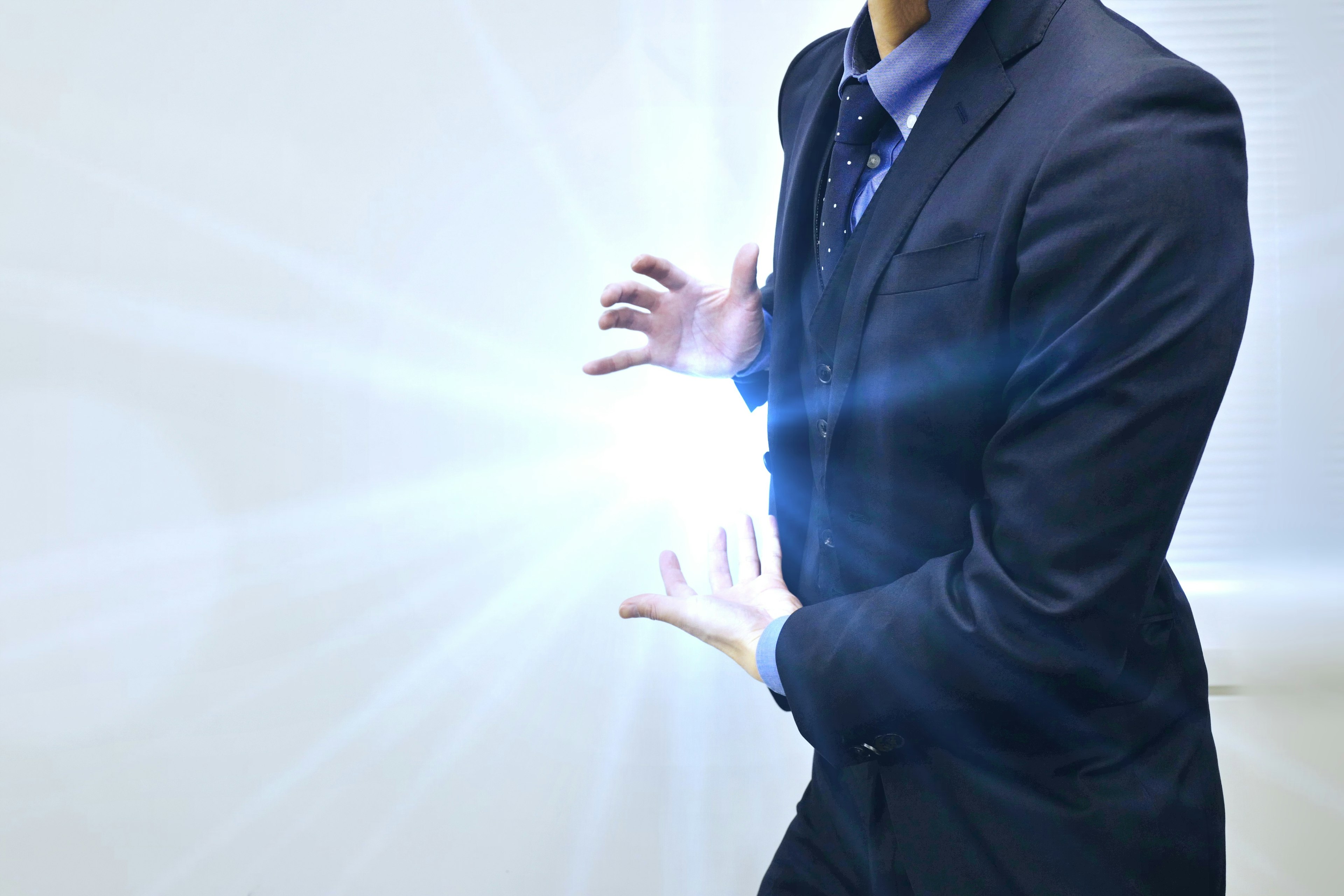 A man in a suit holding glowing light in his hands