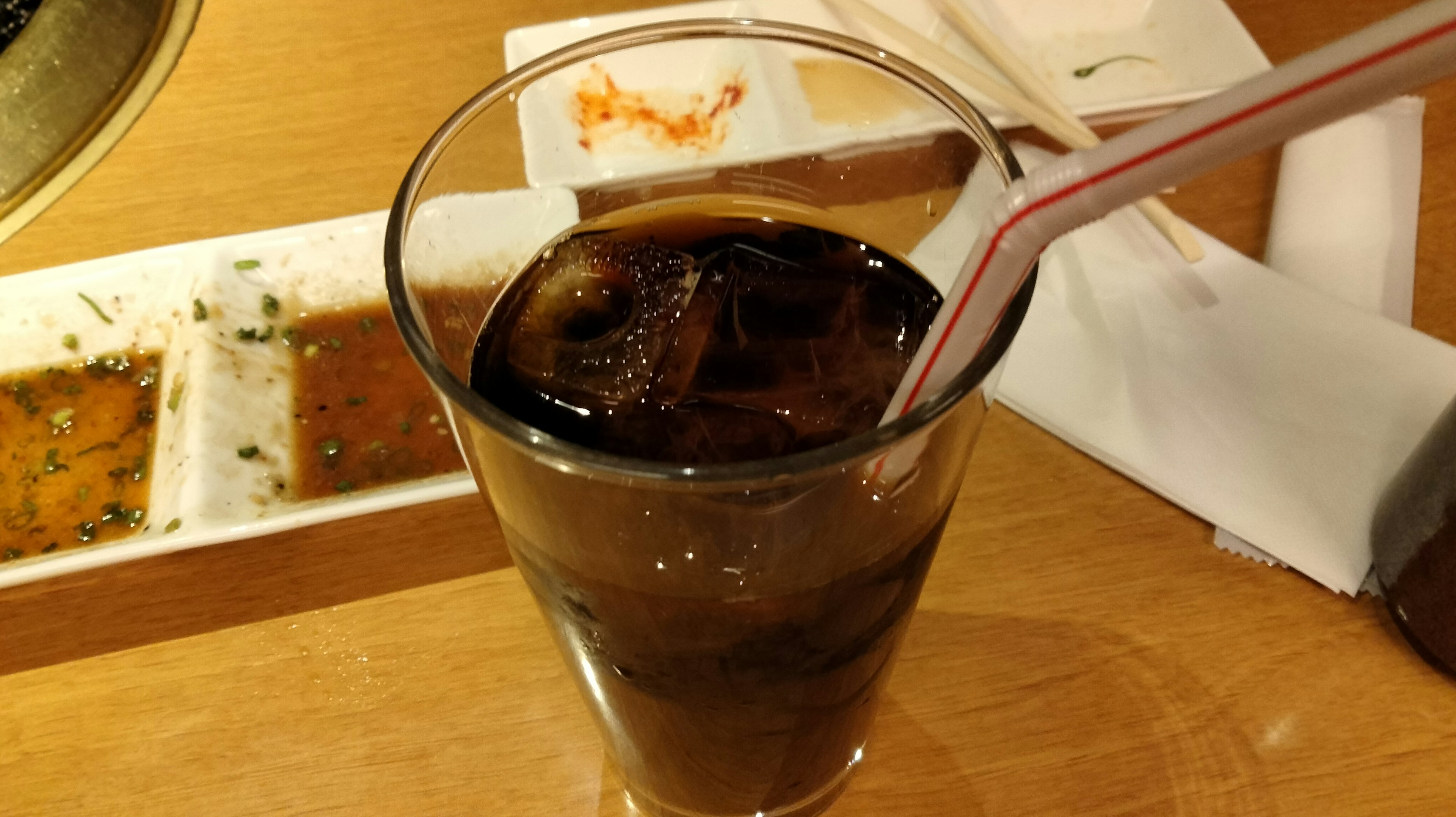 Glas Cola mit Eis und einem Strohhalm