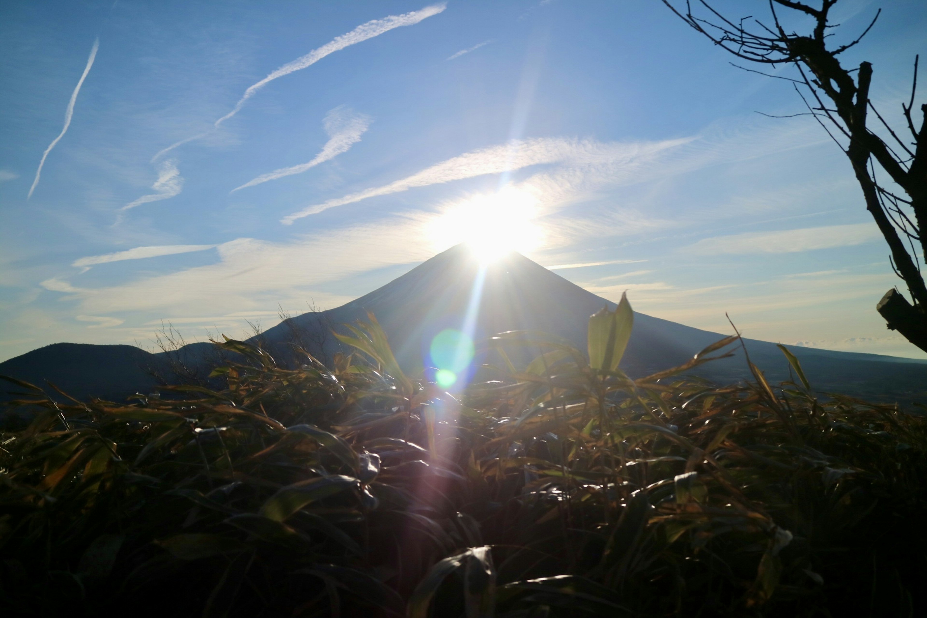 Hermoso paisaje de una montaña con el sol brillando al fondo cielo azul y nubes paisaje natural