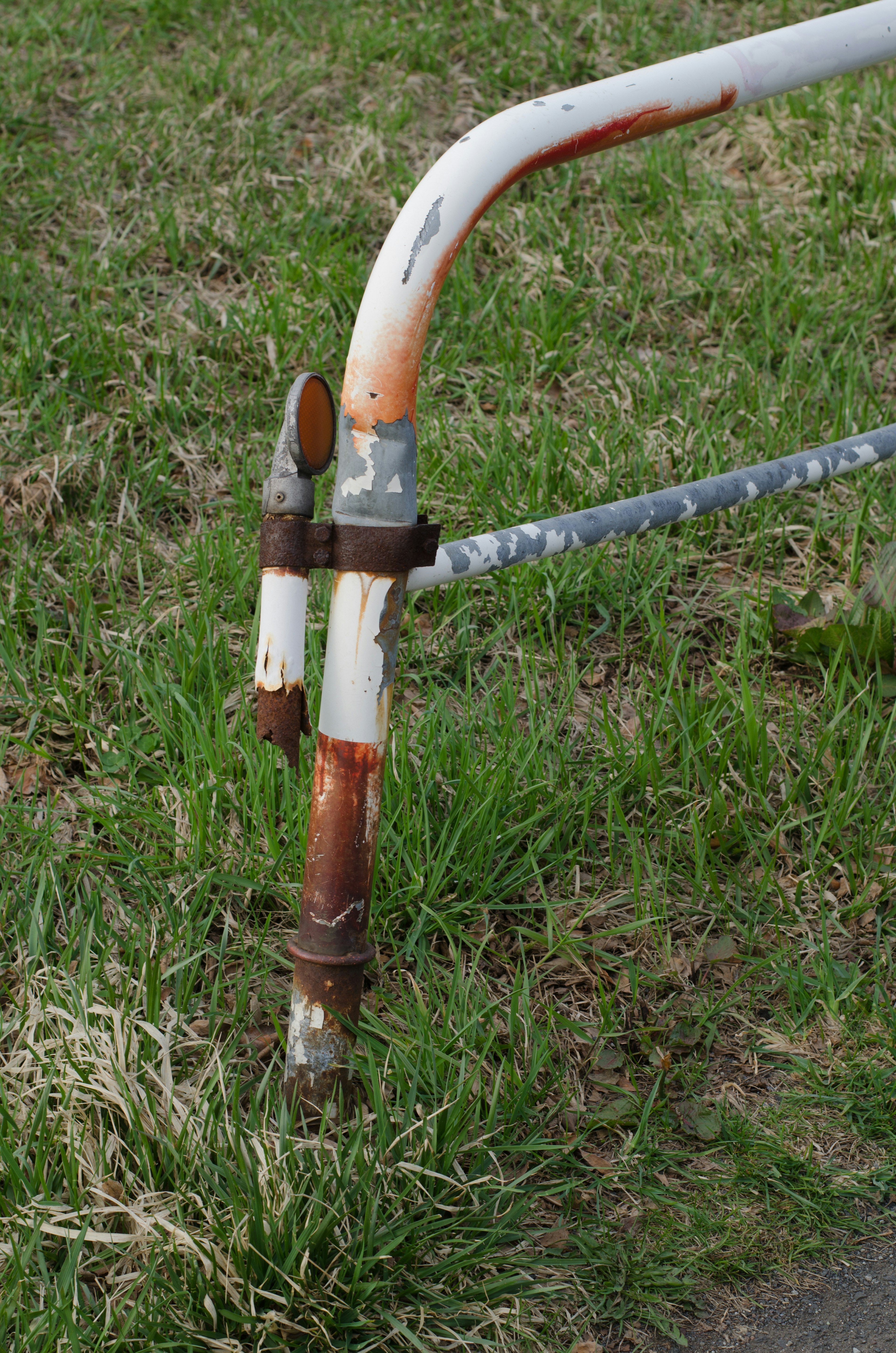 Poteau en métal rouillé se tenant sur de l'herbe