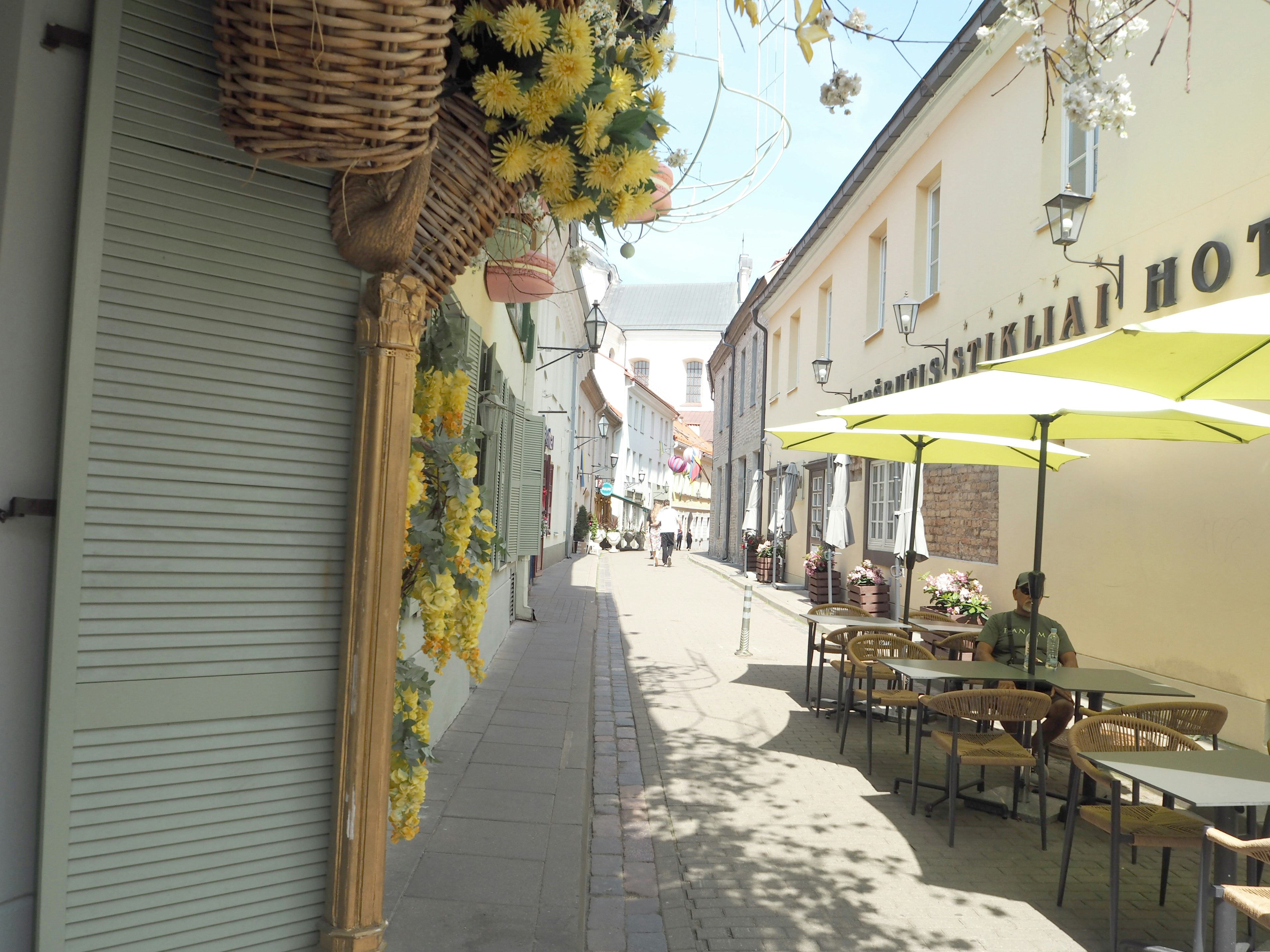 Scène de rue charmante avec des fleurs et des sièges de café en plein air