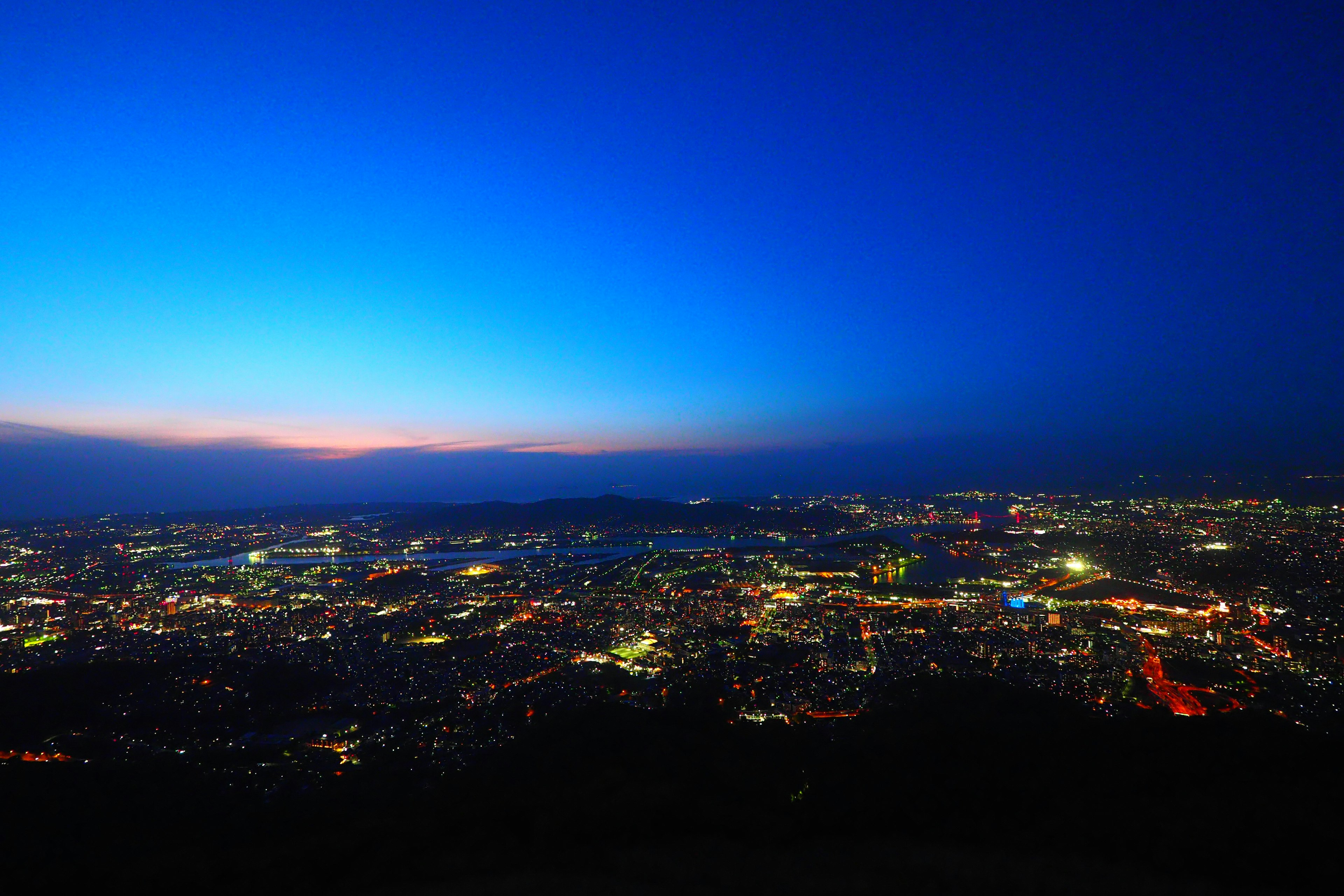 Pemandangan panorama cakrawala kota saat senja dengan langit biru