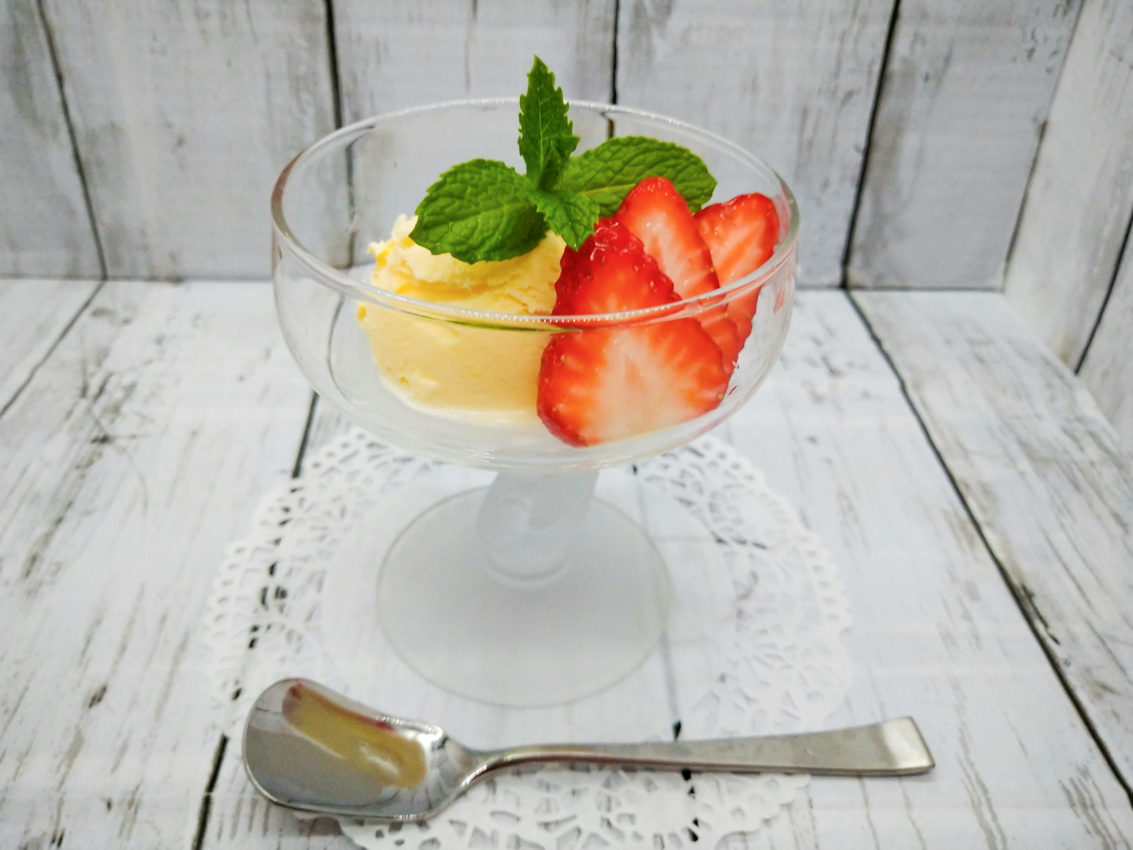 Postre cremoso cubierto con fresas y hojas de menta