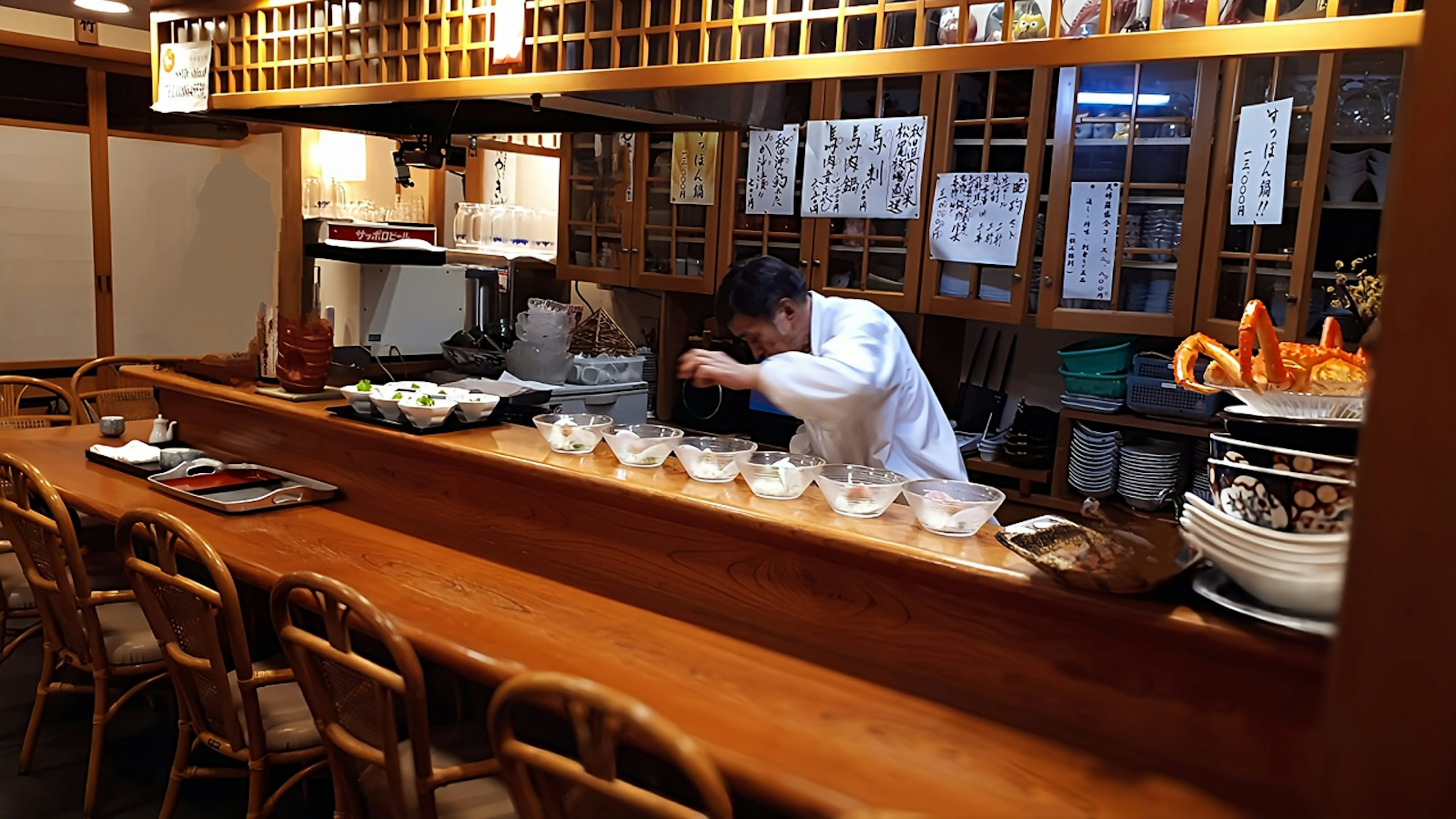 Chef preparing dishes at a Japanese restaurant counter