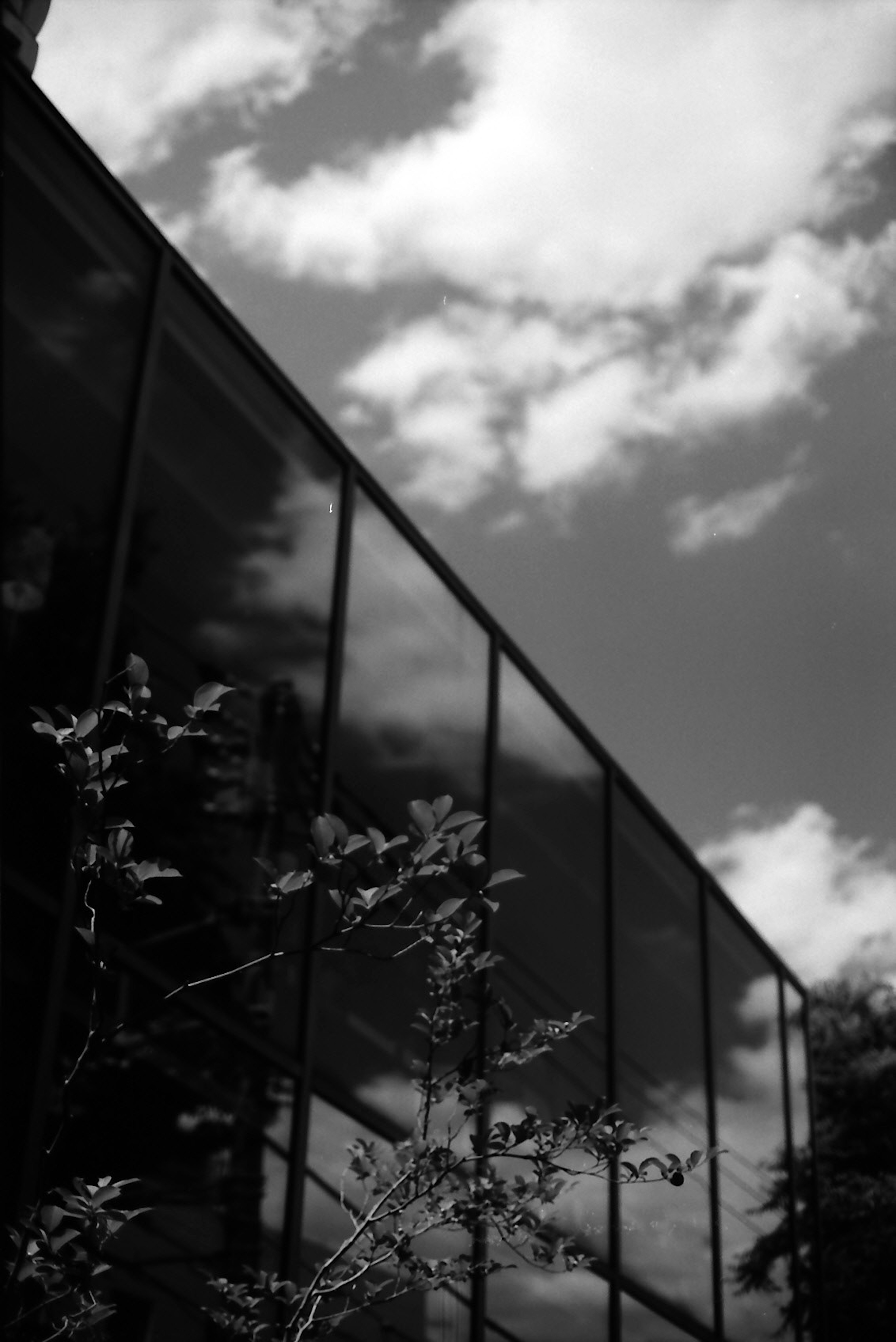 Edificio moderno reflejando nubes en blanco y negro