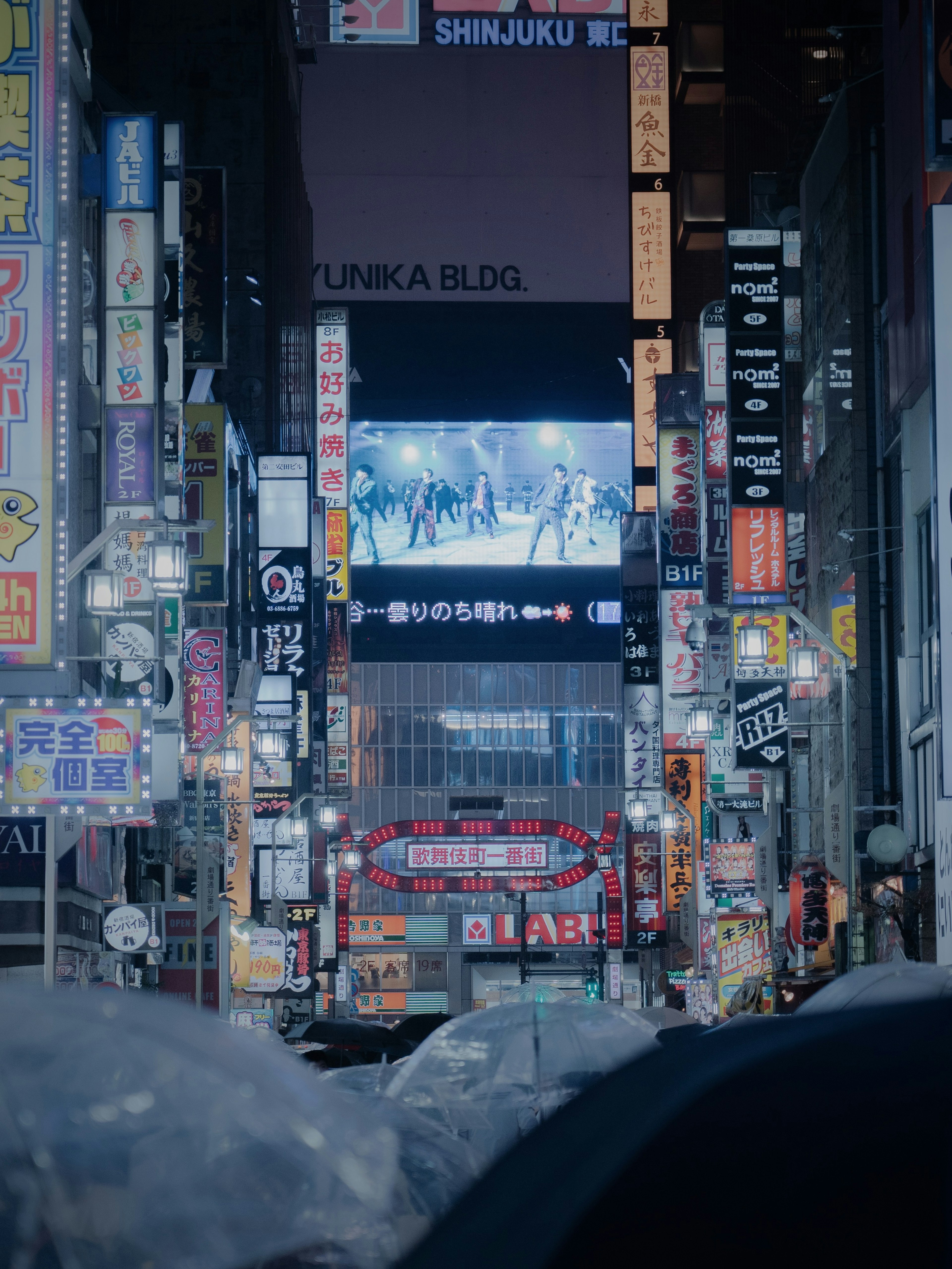 Rue animée de la ville avec des enseignes colorées et une grande publicité numérique