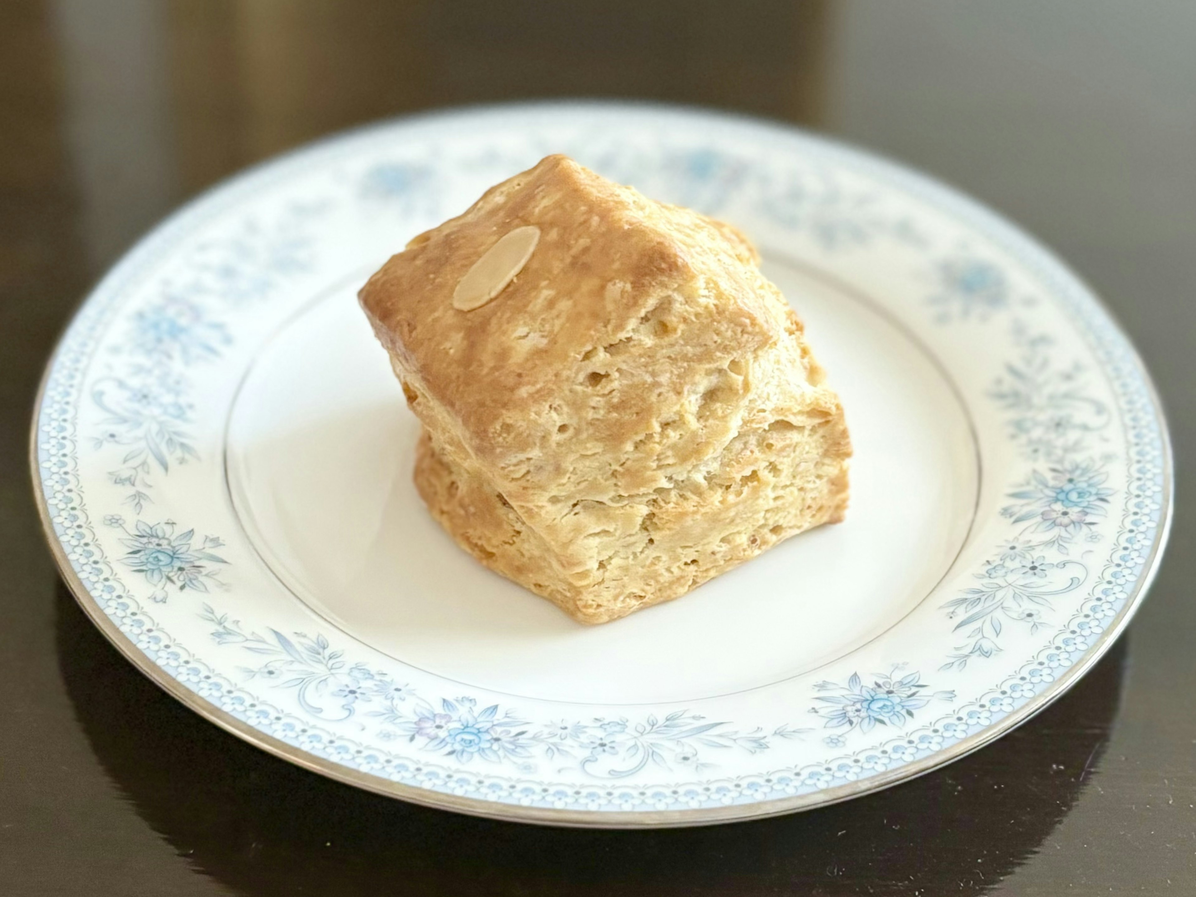 白い花模様の皿の上に置かれた焼き菓子の一切れ