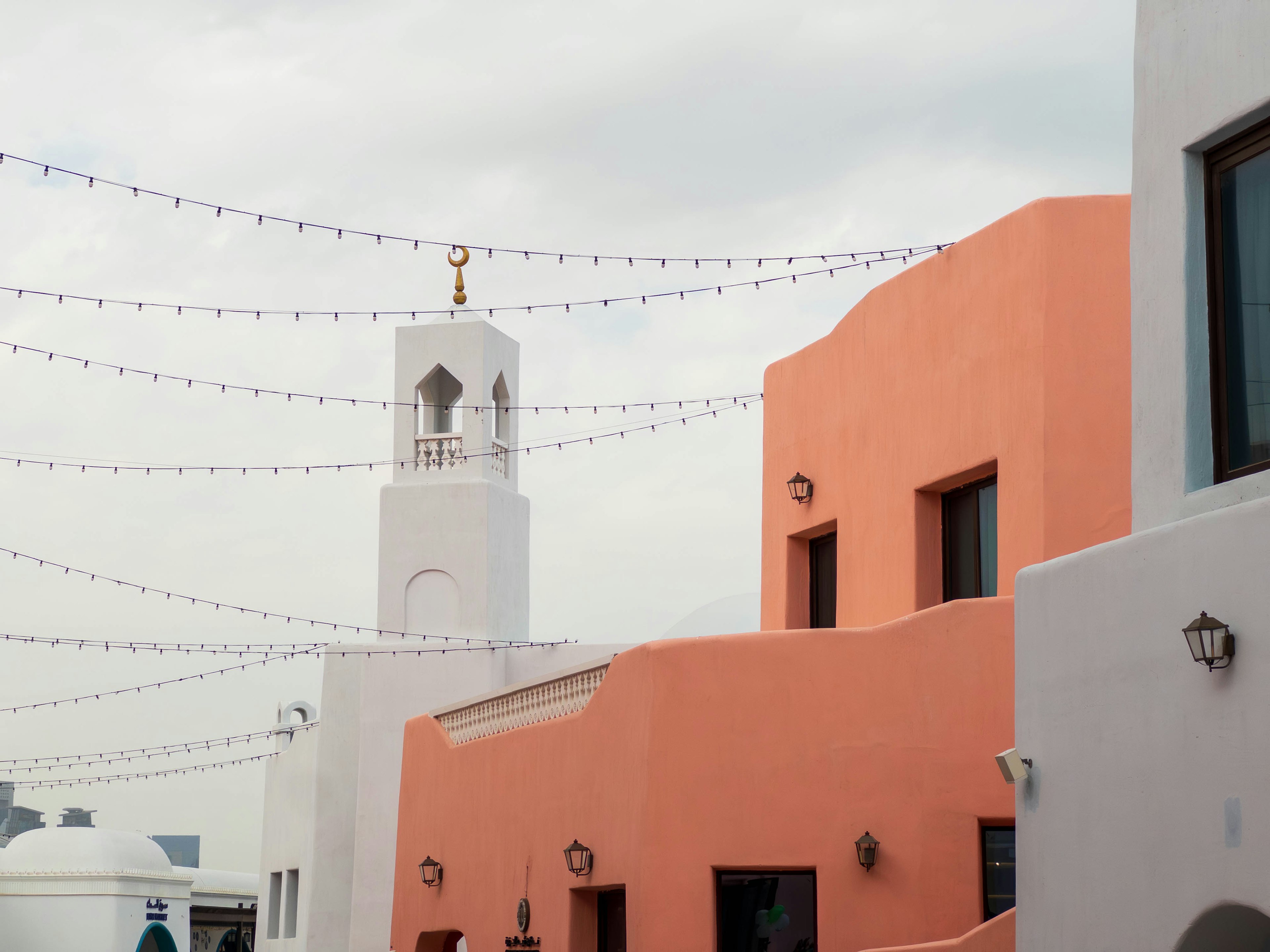 View featuring pink buildings and a white tower with decorative lights