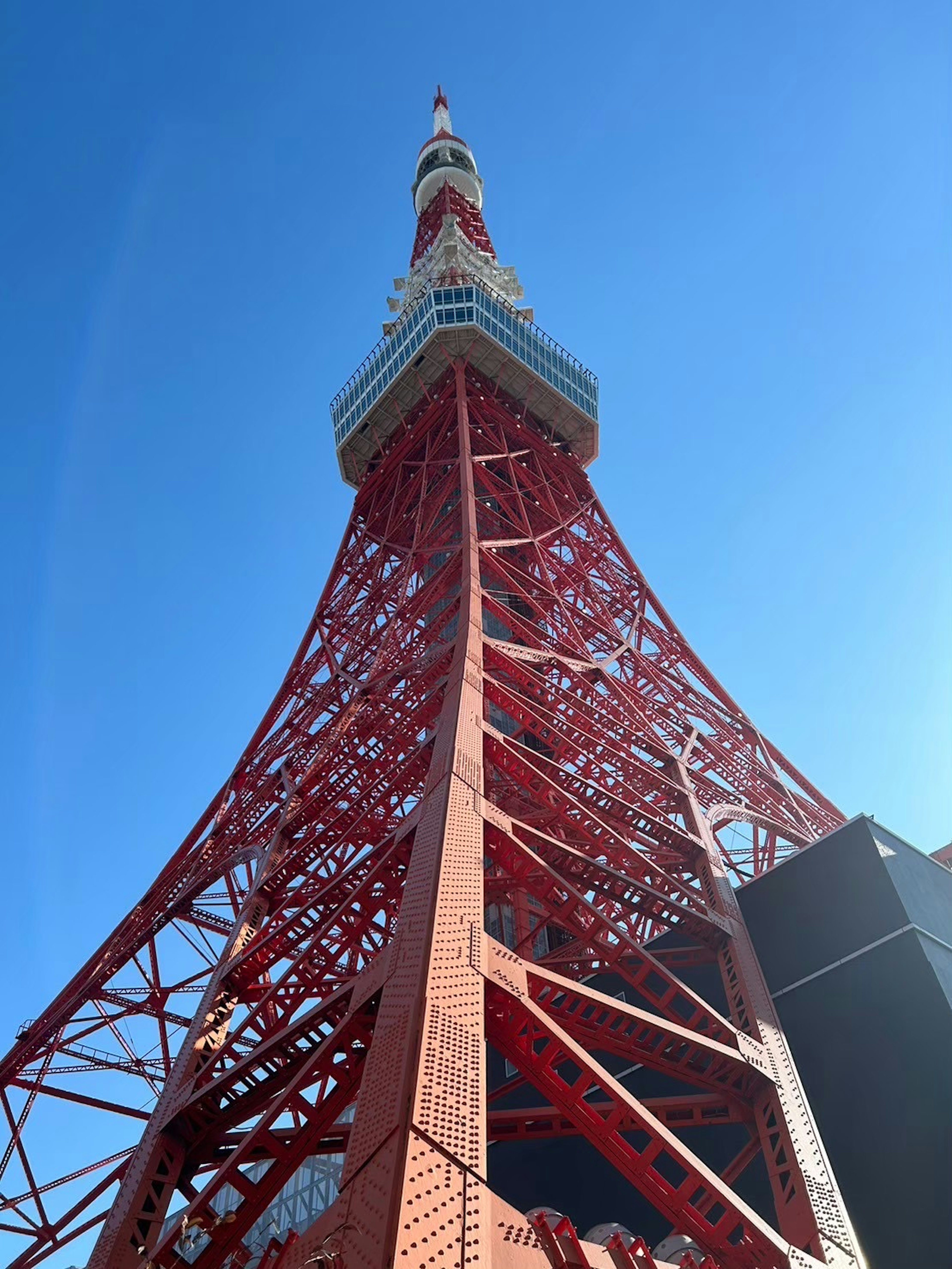 Photo of Tokyo Tower viewed from below Bright blue sky and red structure