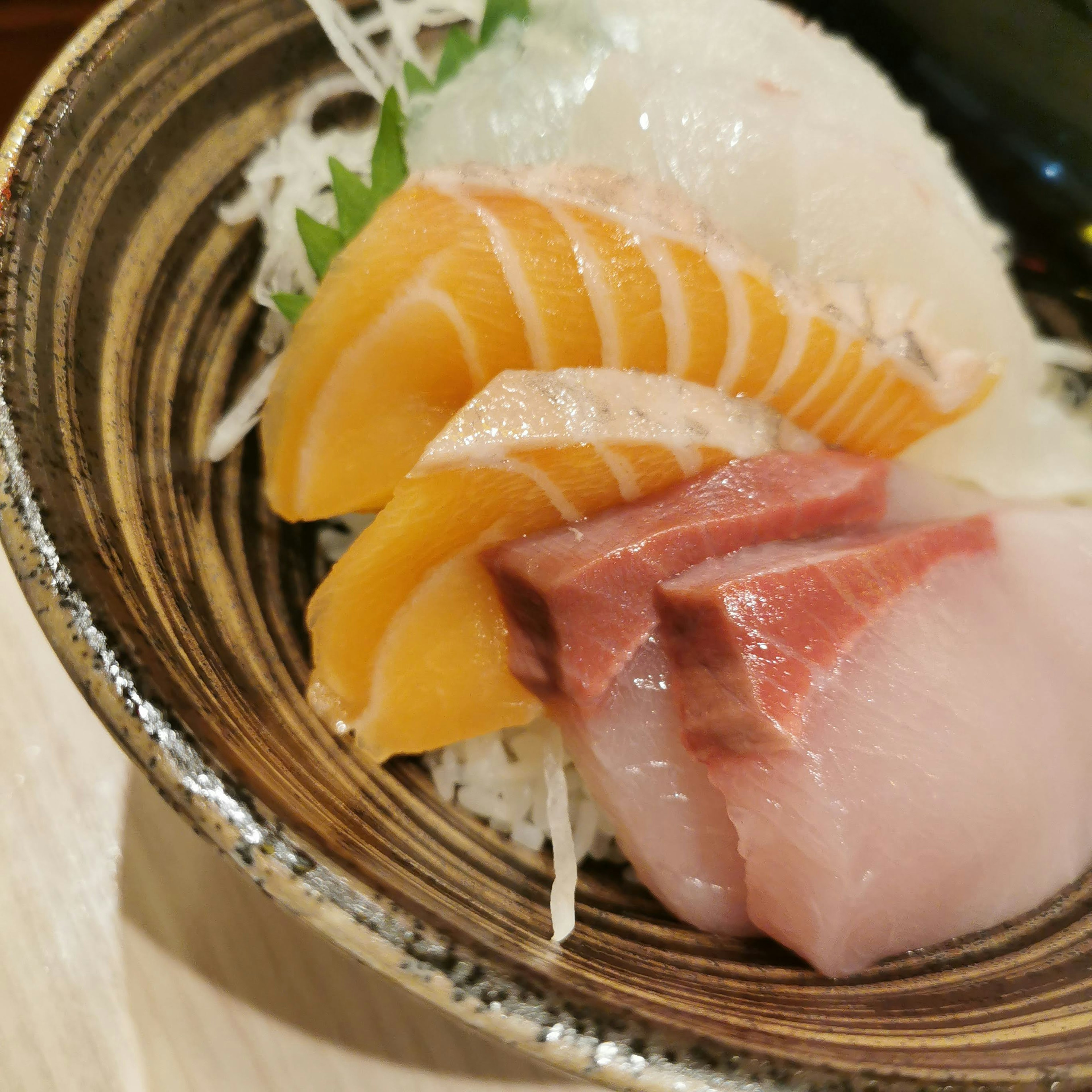 A beautiful arrangement of fresh sashimi served in a decorative bowl