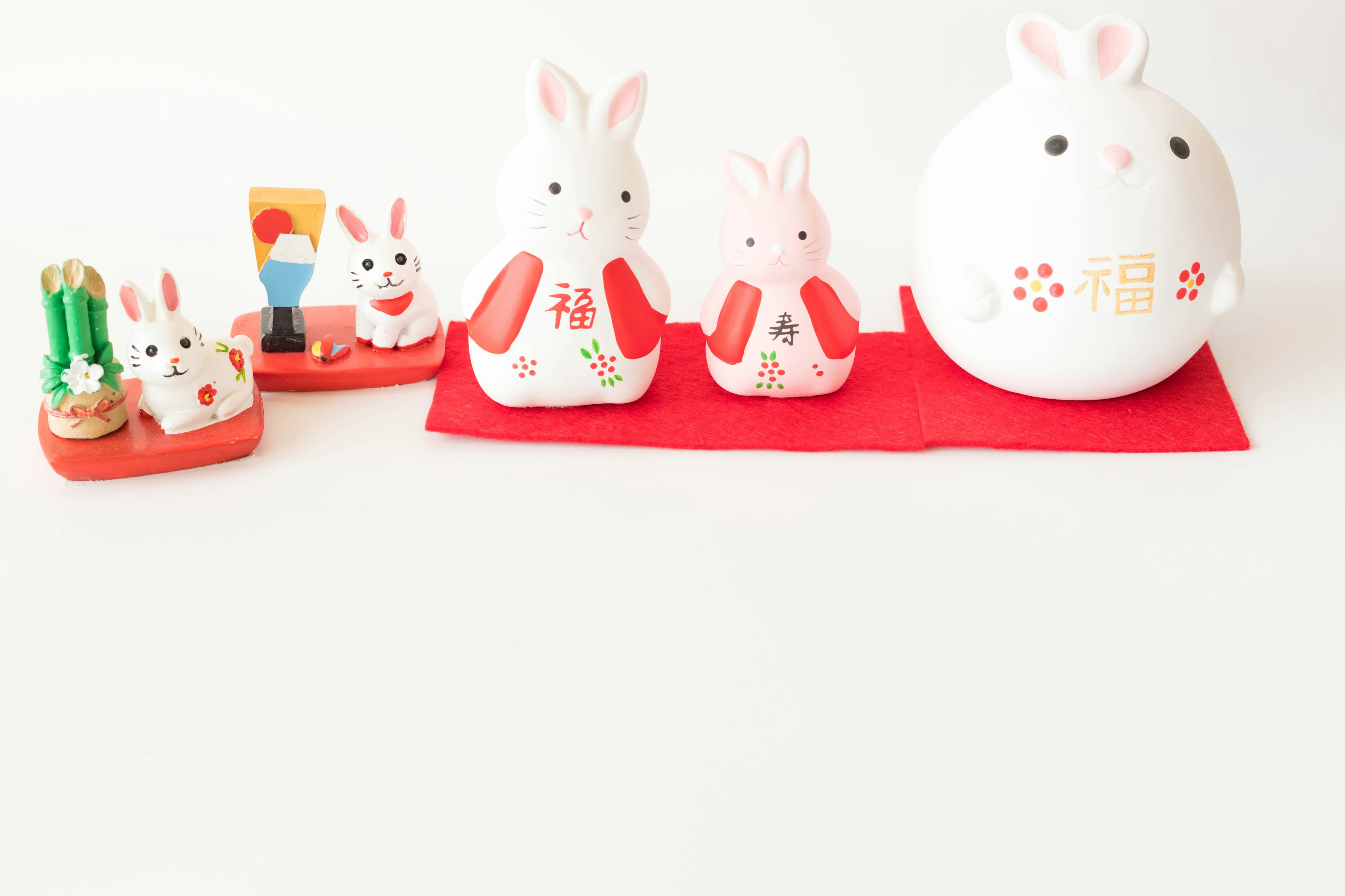 Cute rabbit figurines arranged on a red cloth