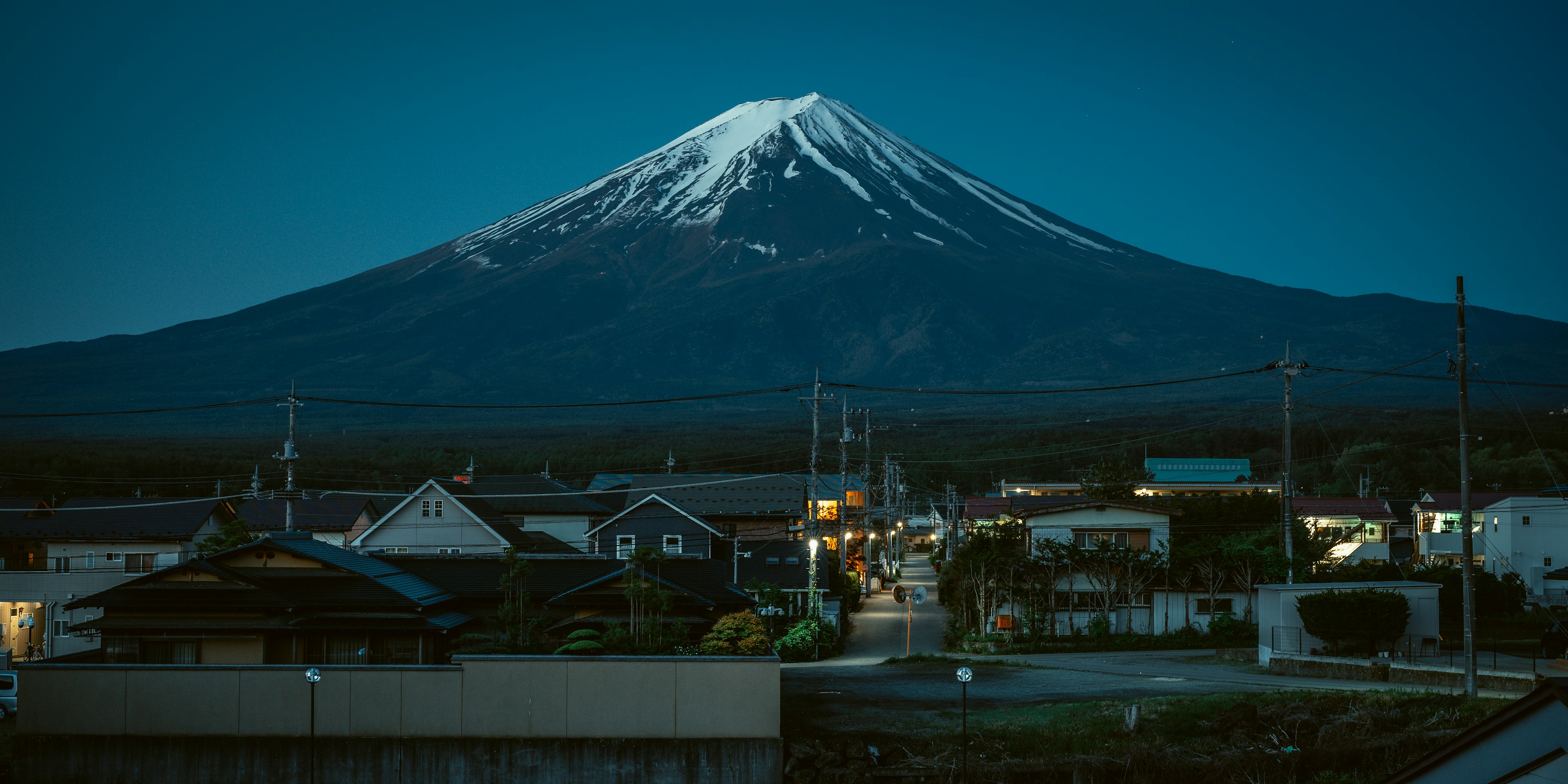 Vue magnifique du mont Fuji la nuit avec des maisons environnantes