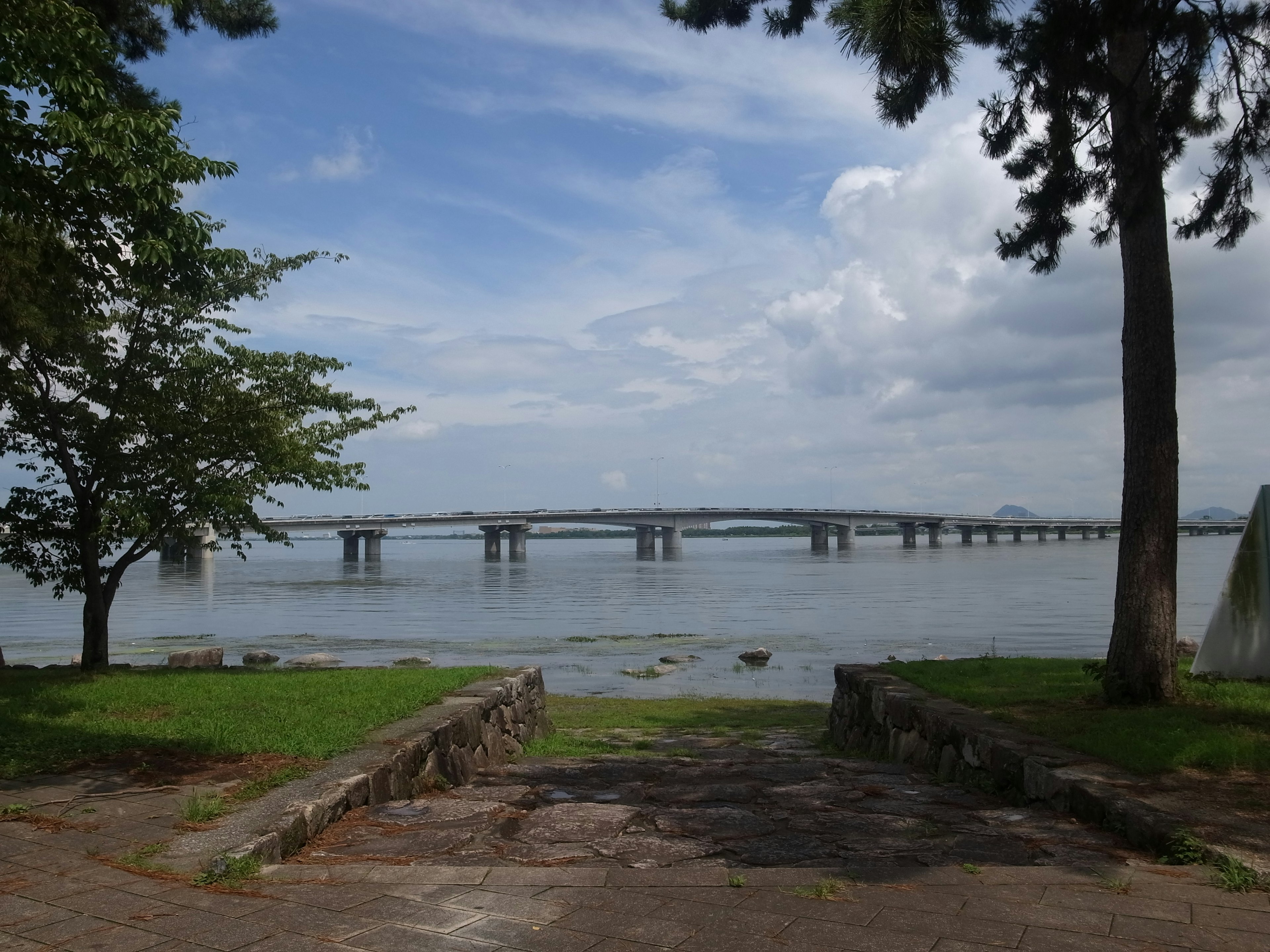 Panoramic view of a calm river with a bridge in the background