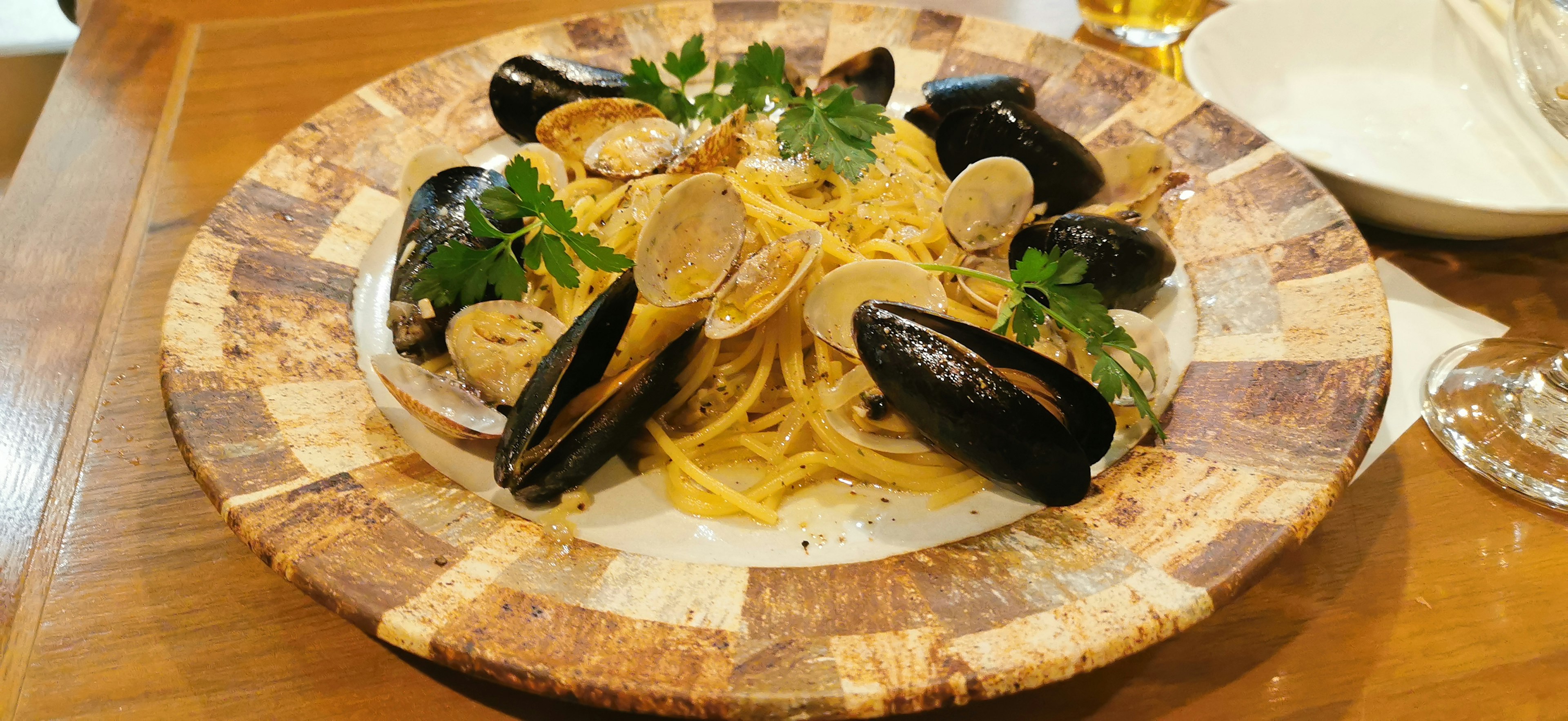 Plato de pasta de mariscos con almejas y mejillones decorado con perejil