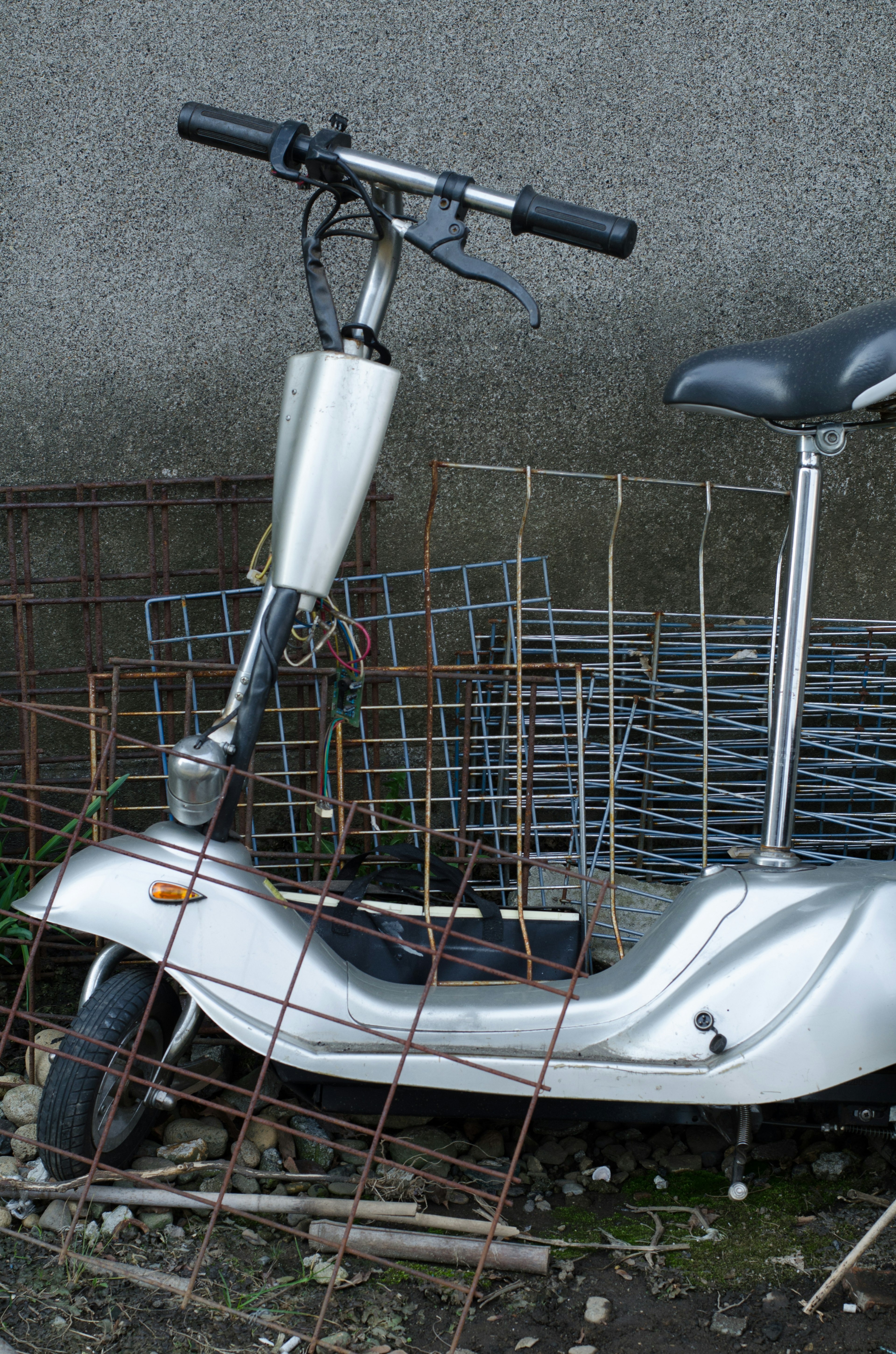 Rusty silver scooter with metal grid