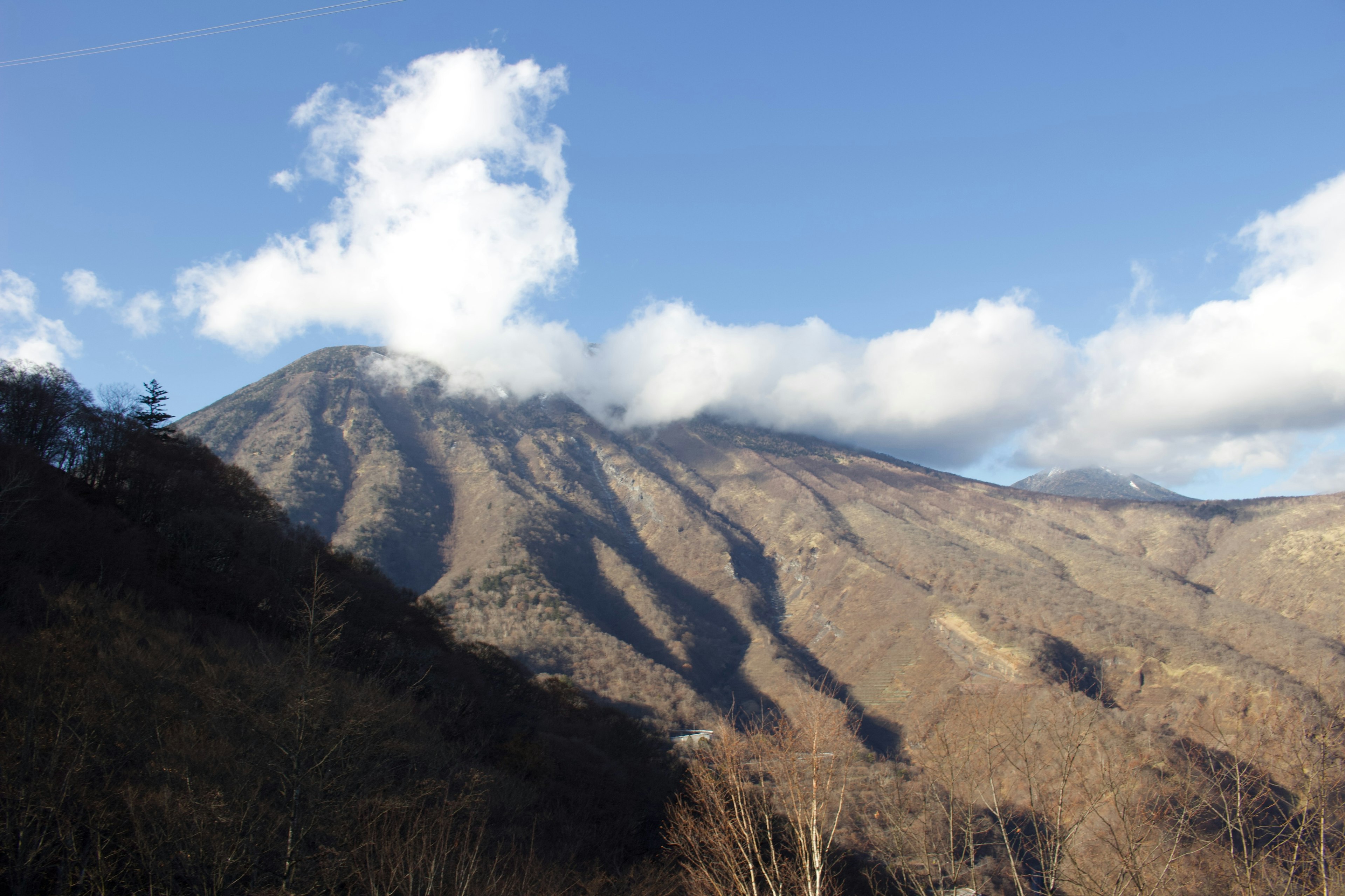 山々が青空の下に広がり雲がかかっている風景