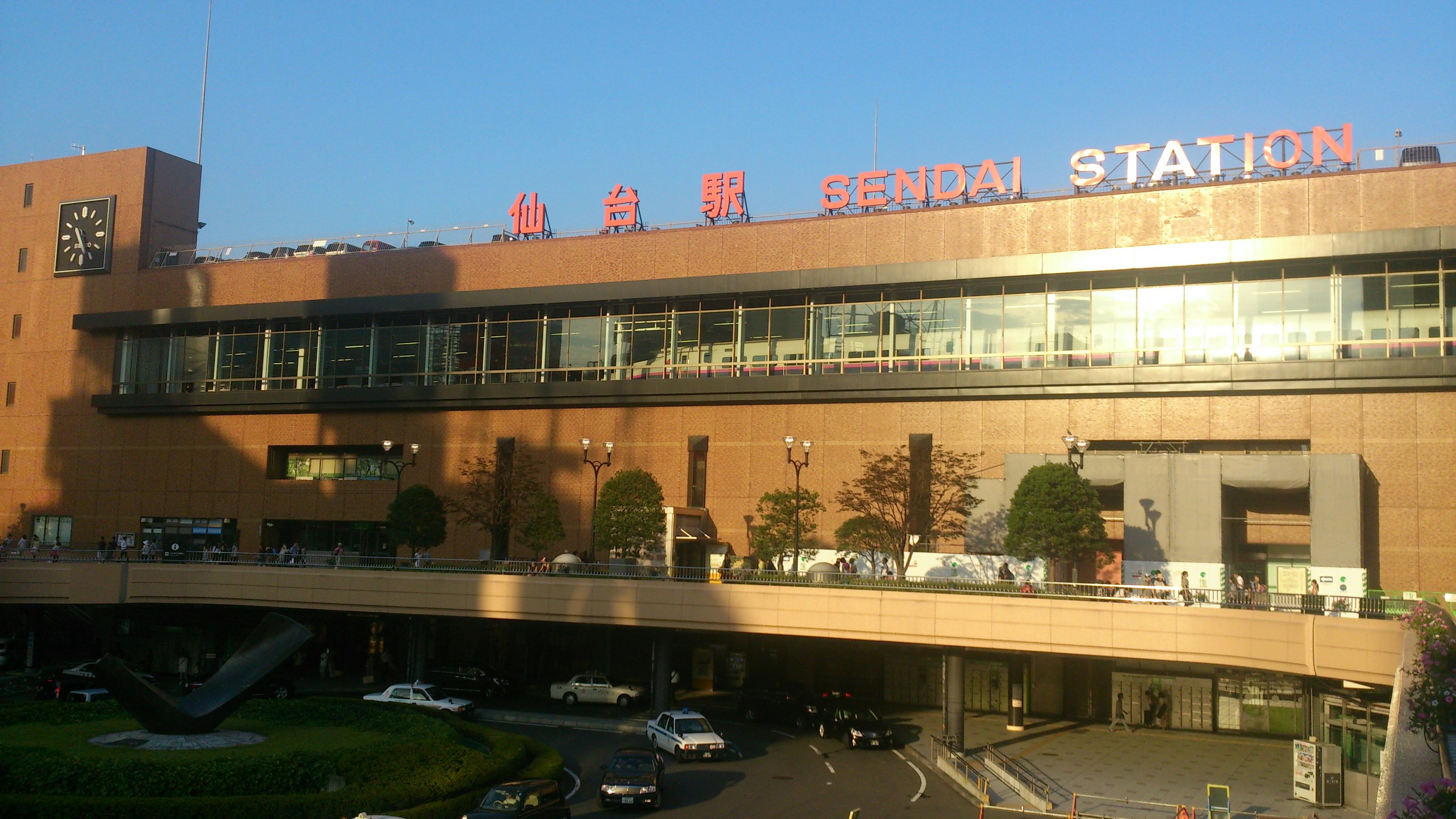 Eksterior Stasiun Niigata di Prefektur Niigata dengan desain modern di latar belakang matahari terbenam