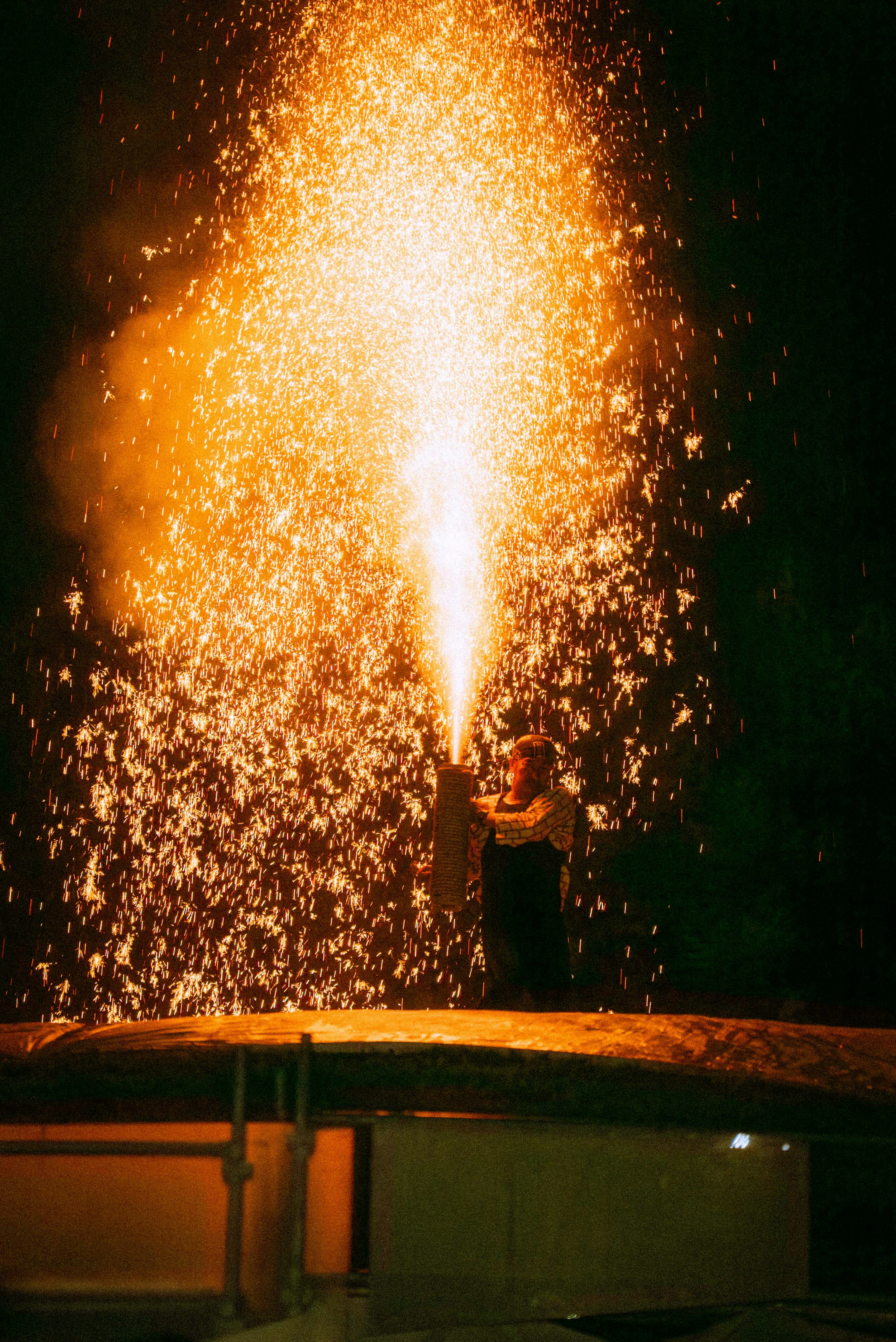 A person shooting sparks into the night sky