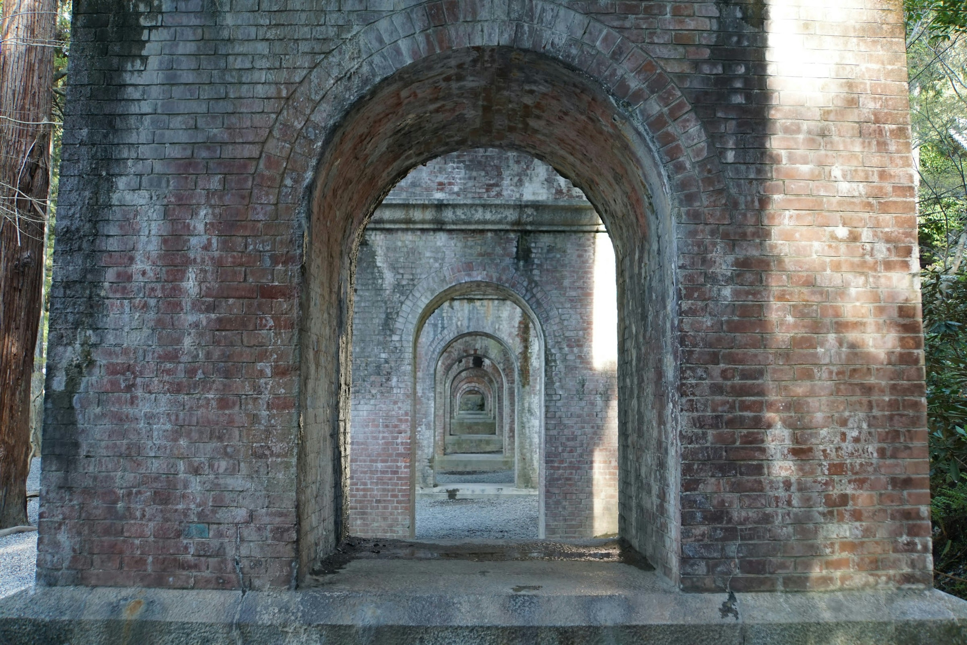 Une série d'arches en briques menant au loin créant un effet de tunnel