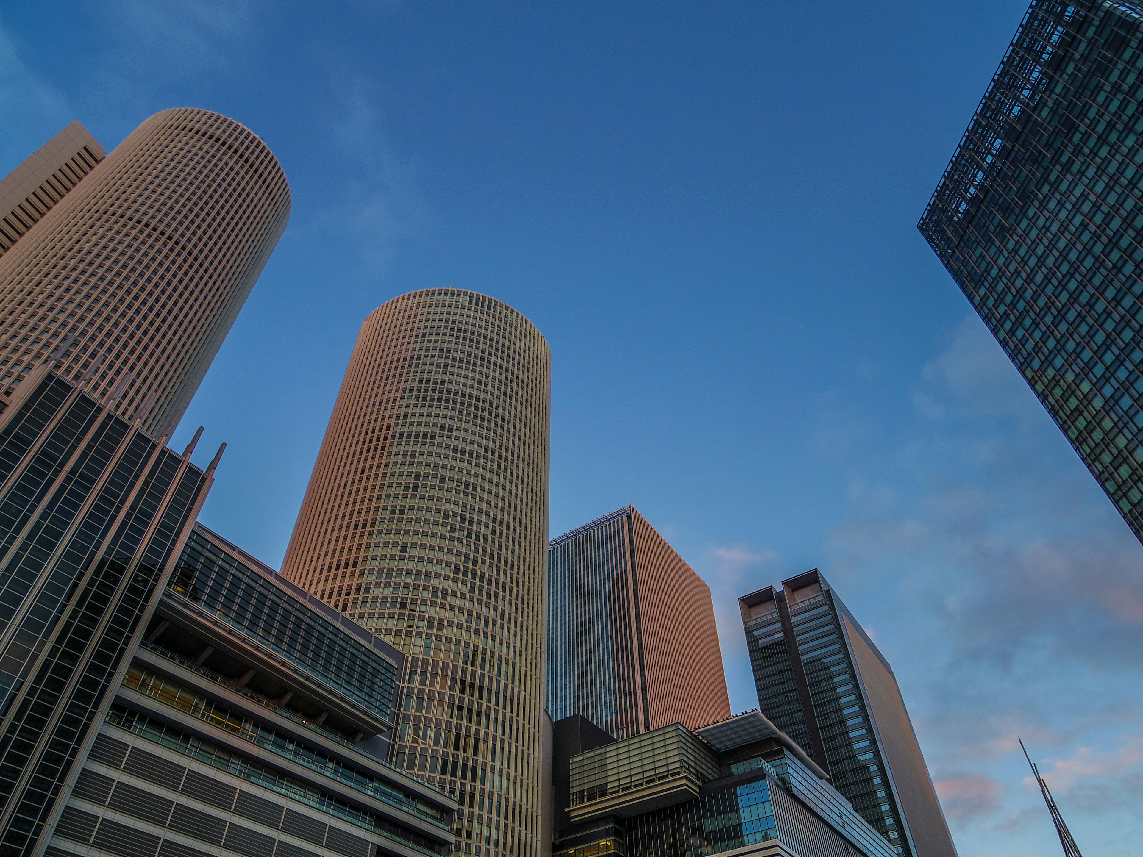 Skyline featuring tall buildings under a blue sky with unique architectural designs