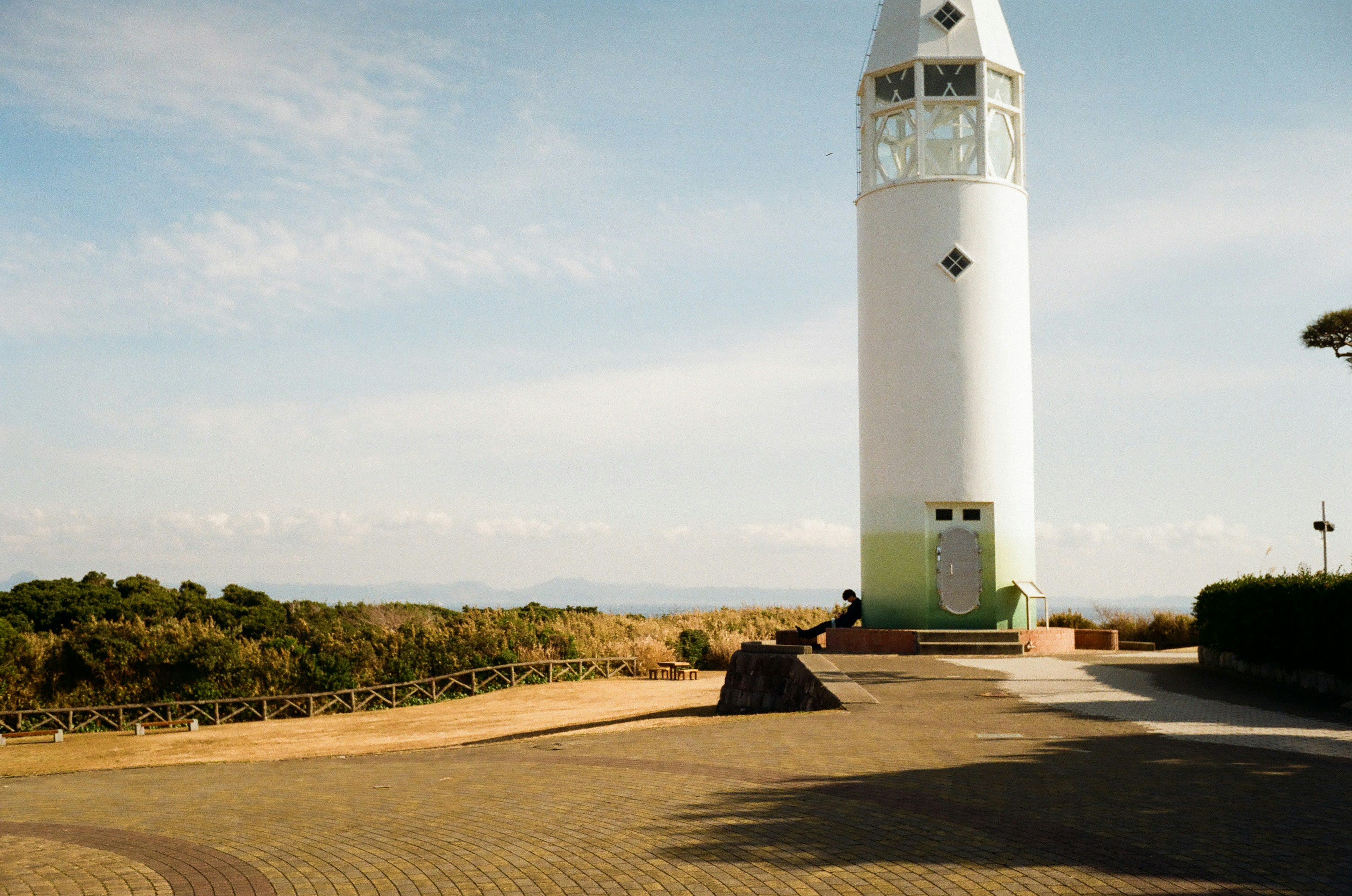 白い灯台がある広い公園の風景