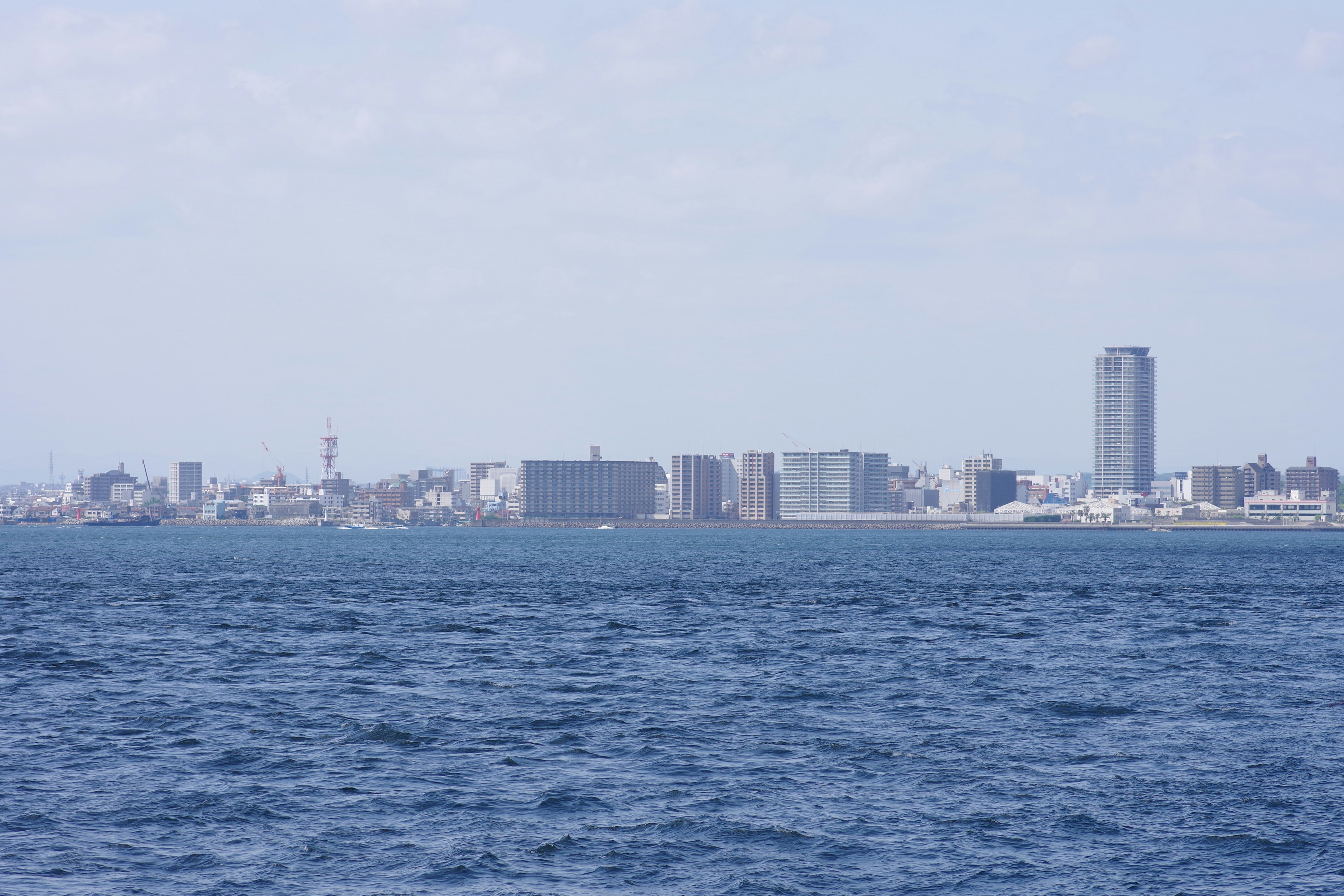 City skyline with buildings and ocean view under clear sky