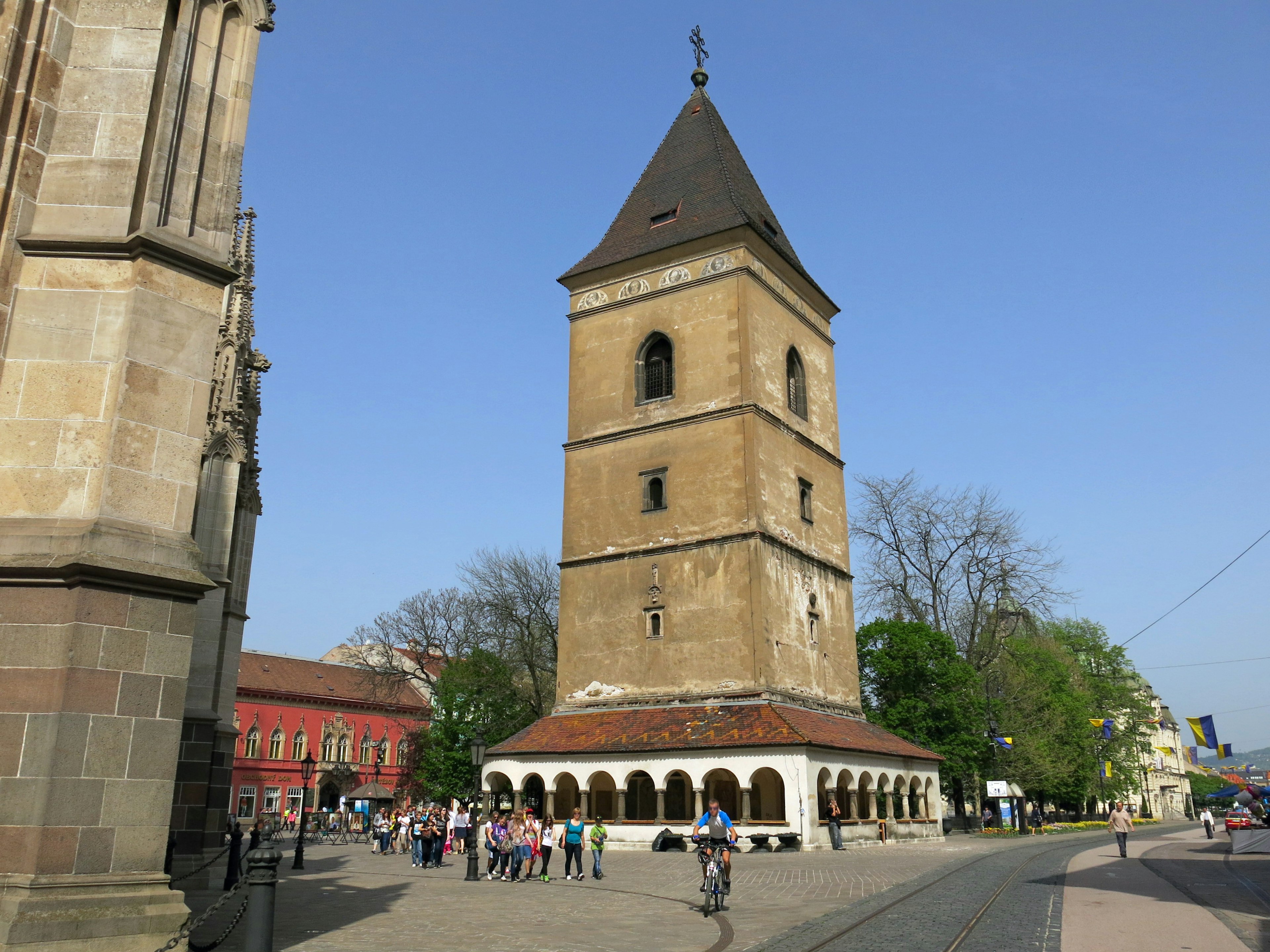 Historic tower standing in a square under a blue sky