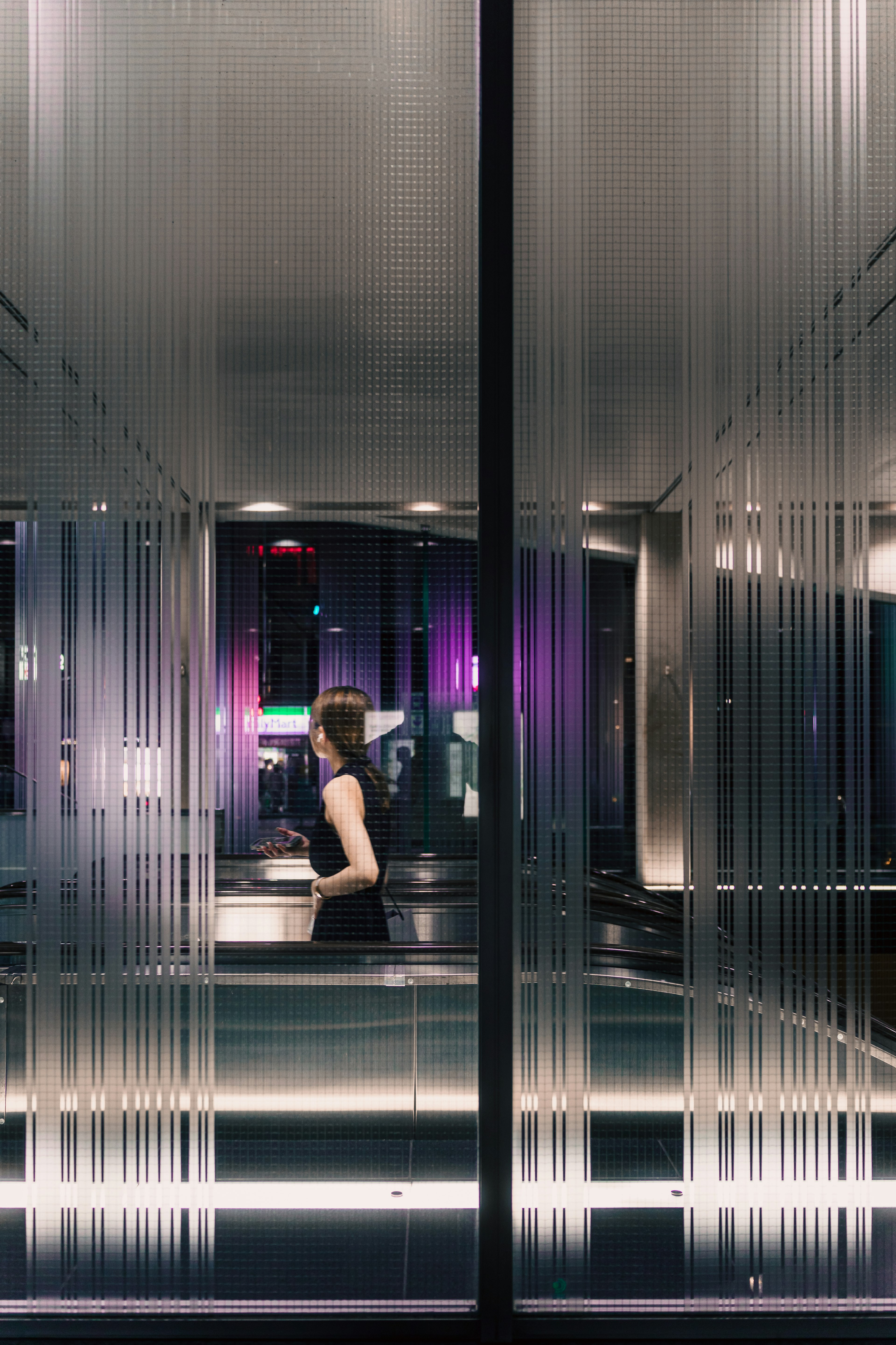 Silhouette of a woman against glass walls with vibrant lighting