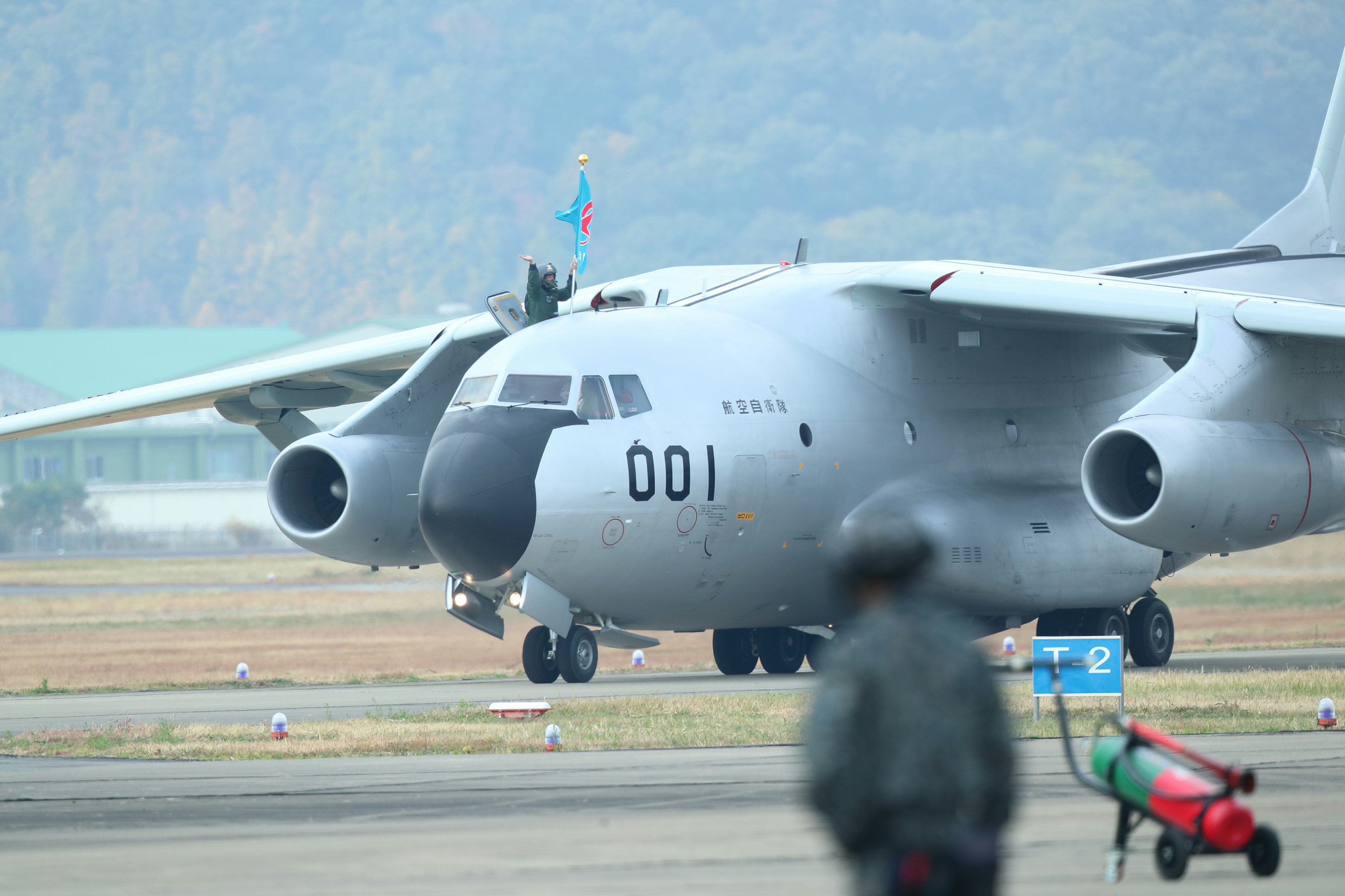 Military aircraft 001 on the runway with a soldier