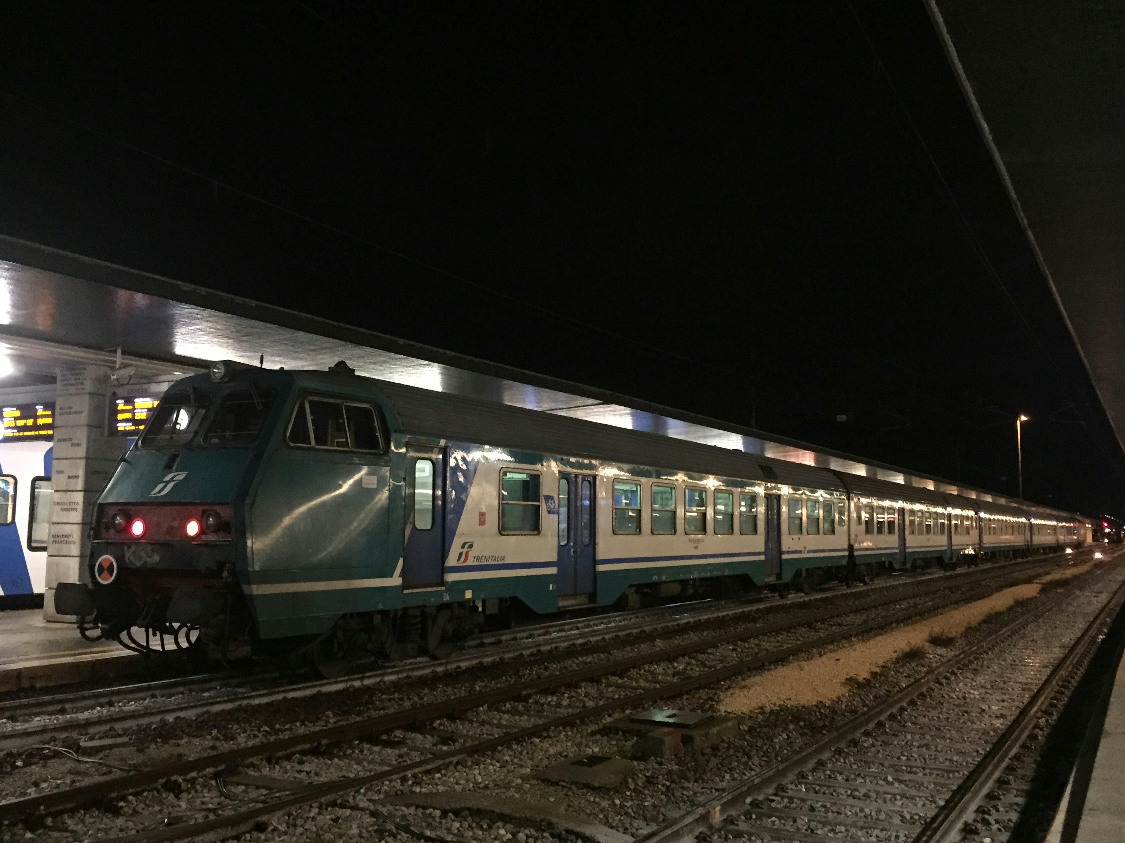 夜の駅に停車中の青い列車の側面