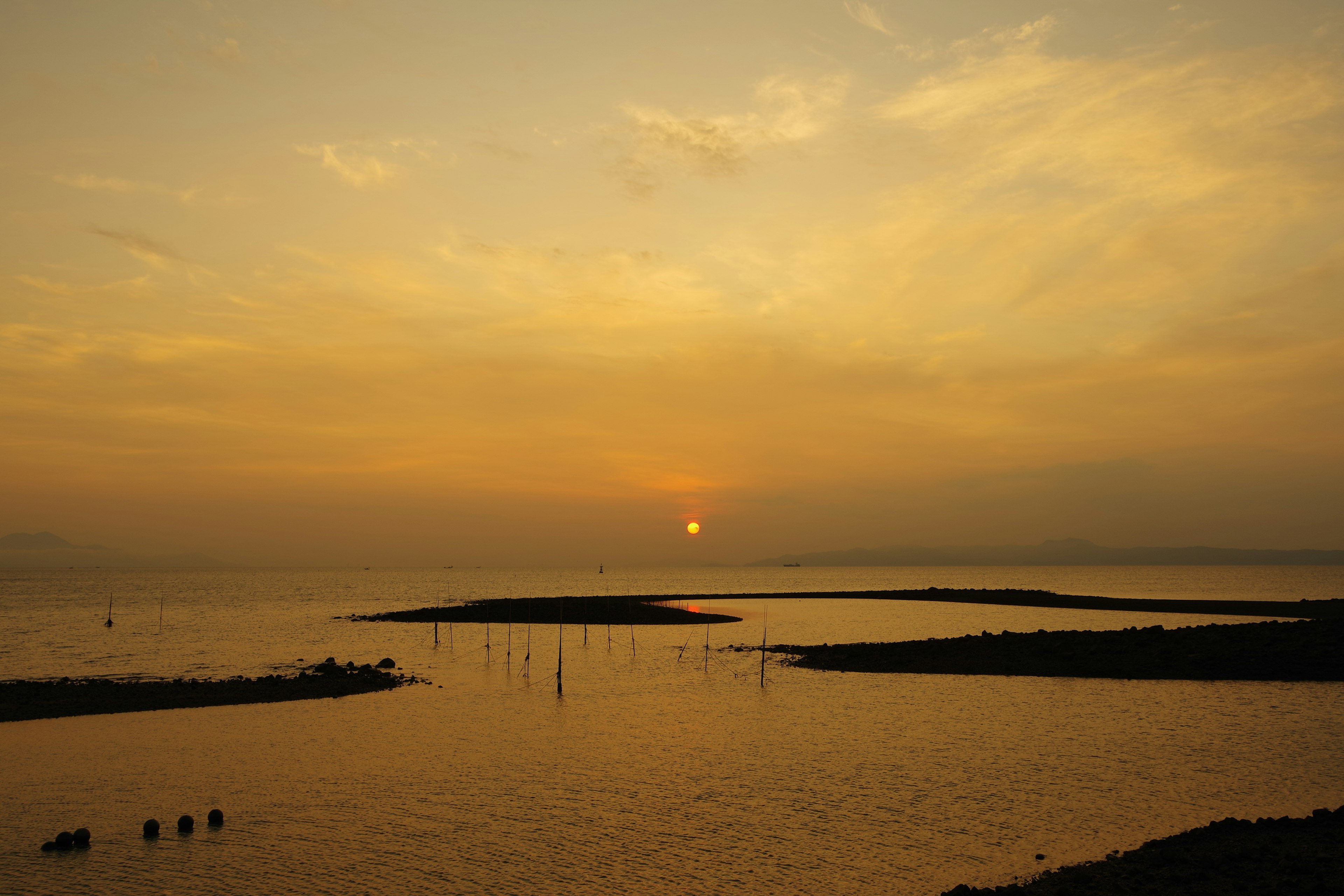 Ruhige Meereslandschaft mit Sonnenuntergang, der sich im Wasser spiegelt