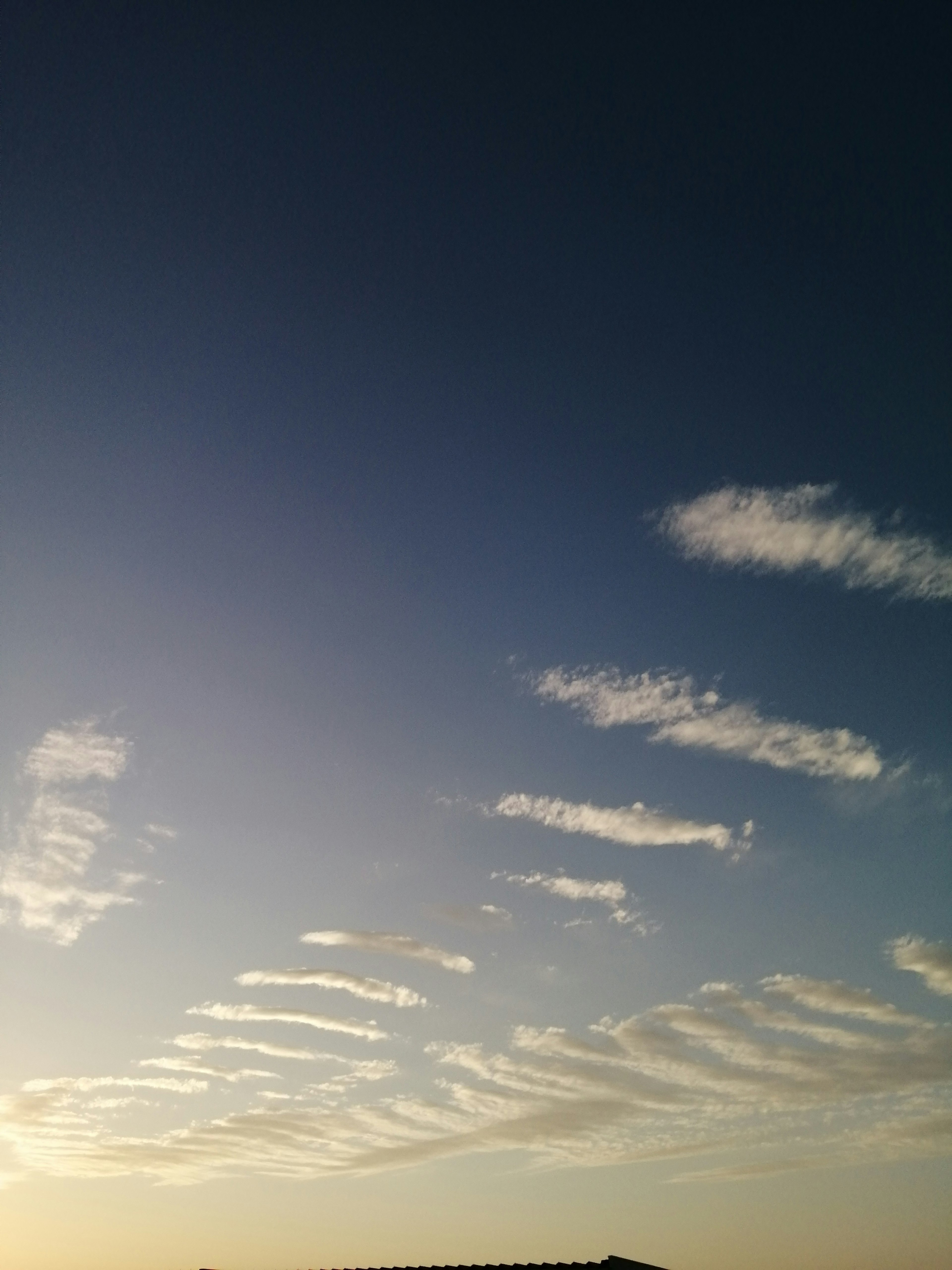 Un paisaje con bandas de nubes blancas en un cielo azul